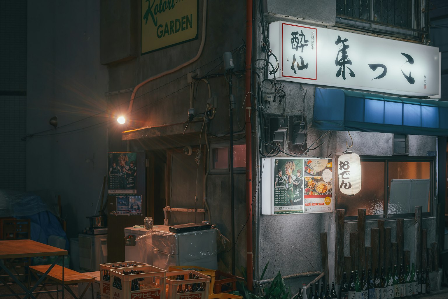 夜間日本居酒屋的外觀，特色明亮的招牌和海報