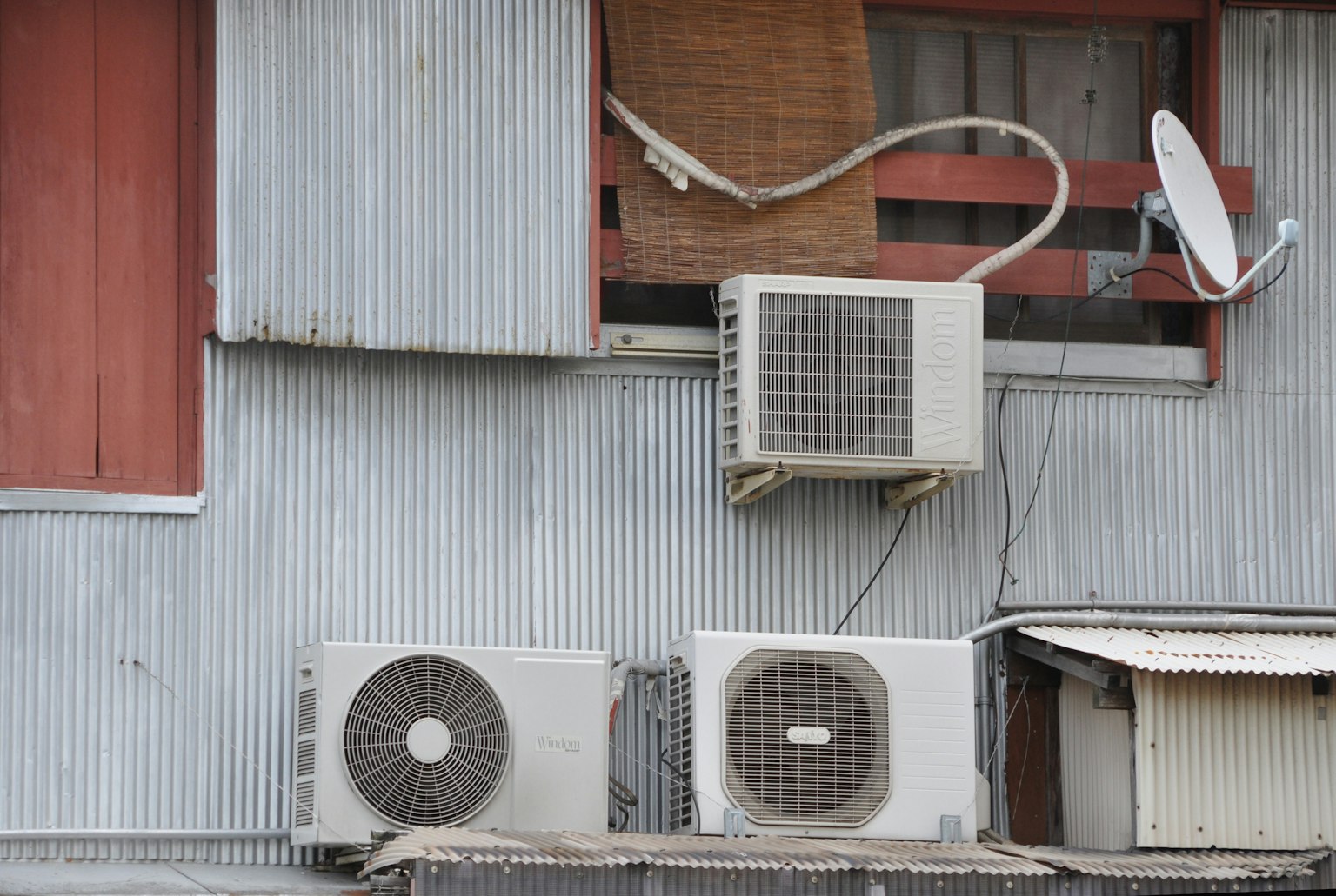 Unità di climatizzazione e antenna satellitare montate su un muro testurizzato