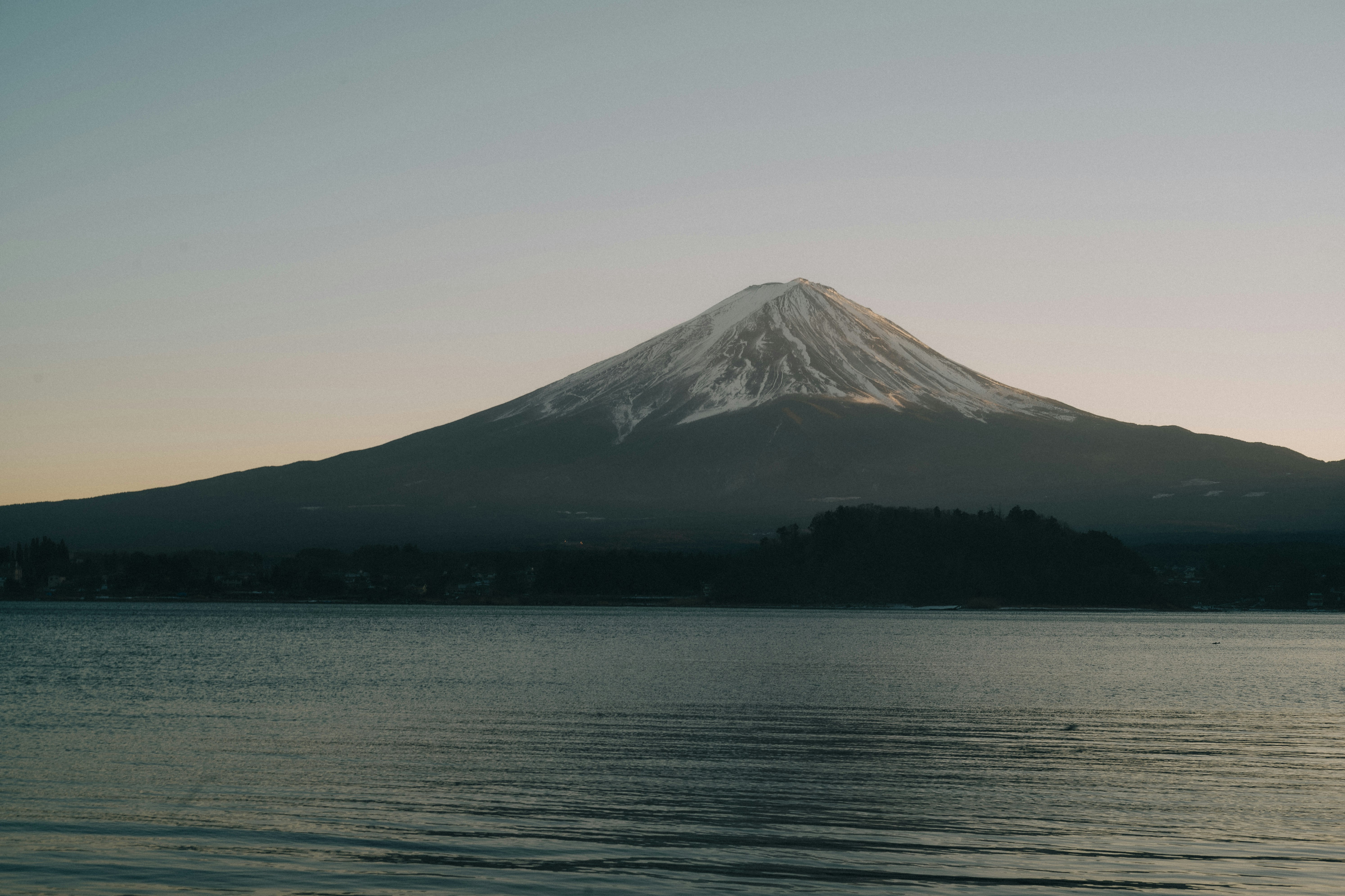 湖畔から見えるシルエットの富士山