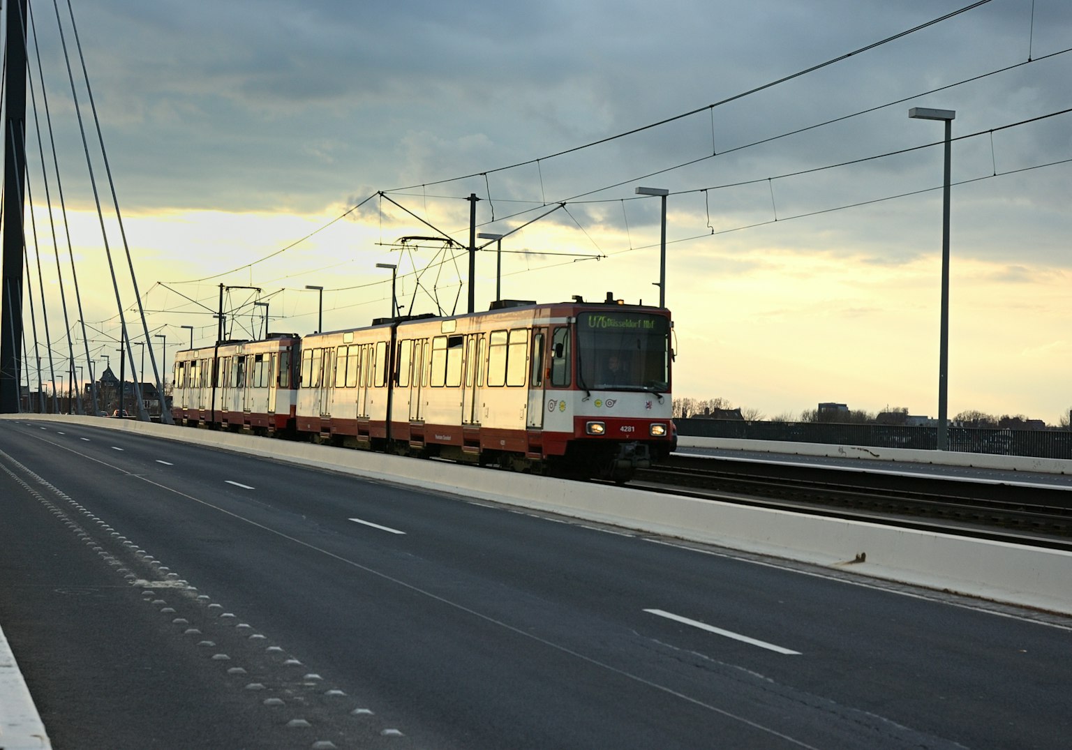 Tren viajando al anochecer con una carretera tranquila