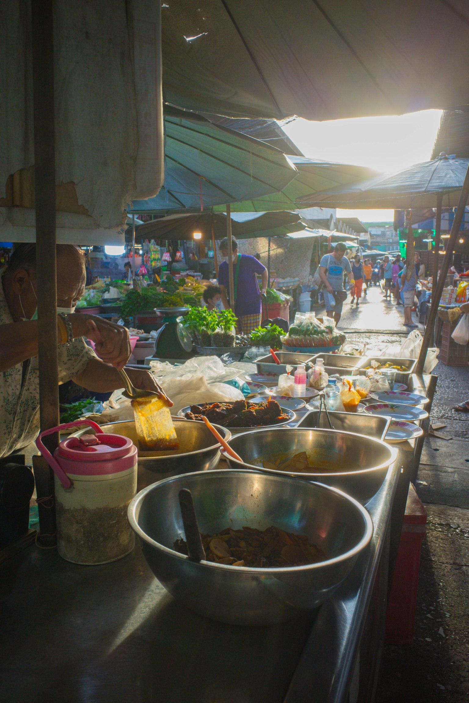แผงขายของตลาดที่มีชามและวัตถุดิบสดใสใต้ร่ม