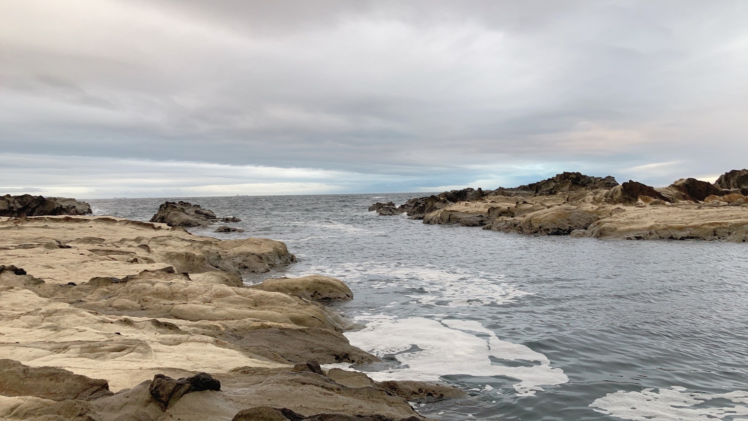 Coastal landscape featuring rocky shores and gentle waves