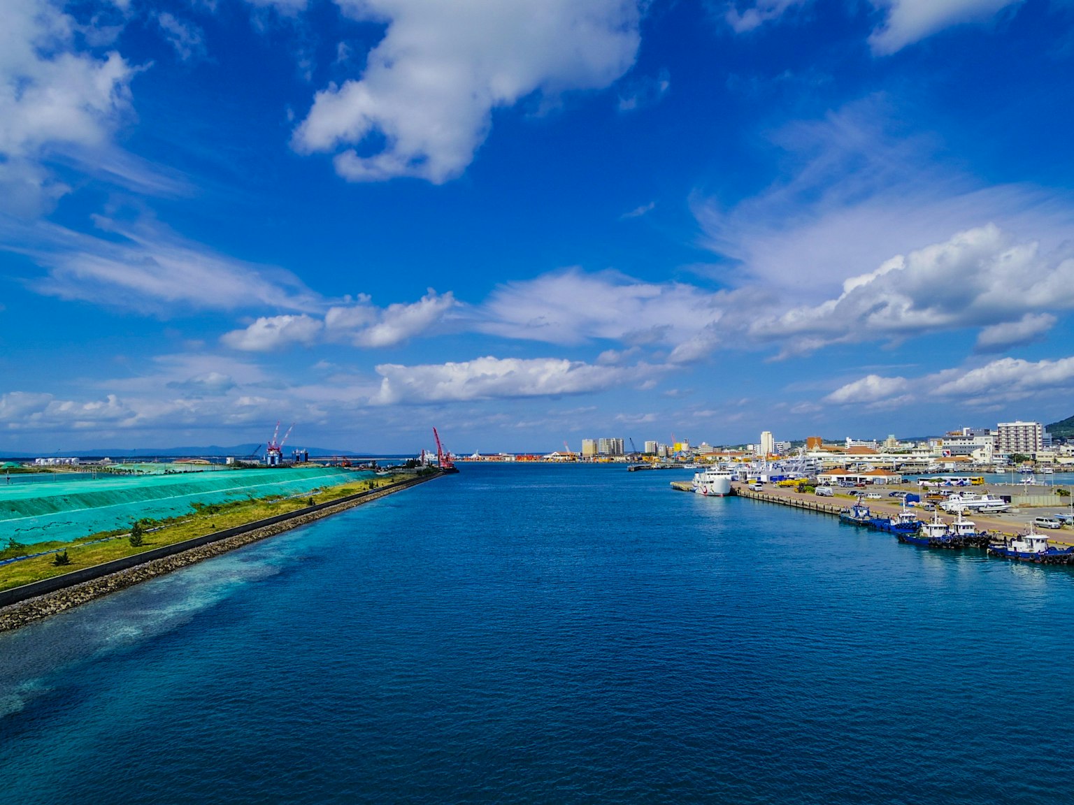 A vibrant harbor scene with blue water and bright sky