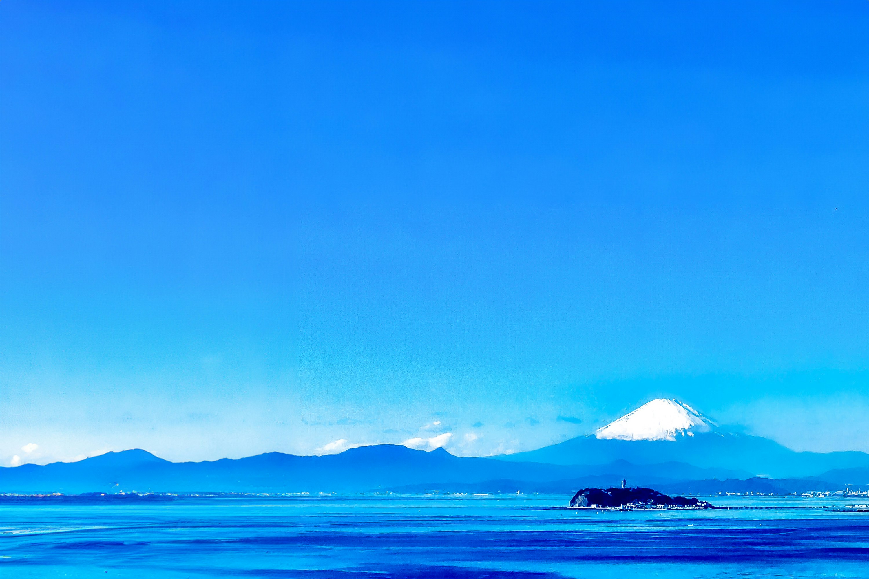 Silhouette des Fuji von der Küste unter klarem blauem Himmel