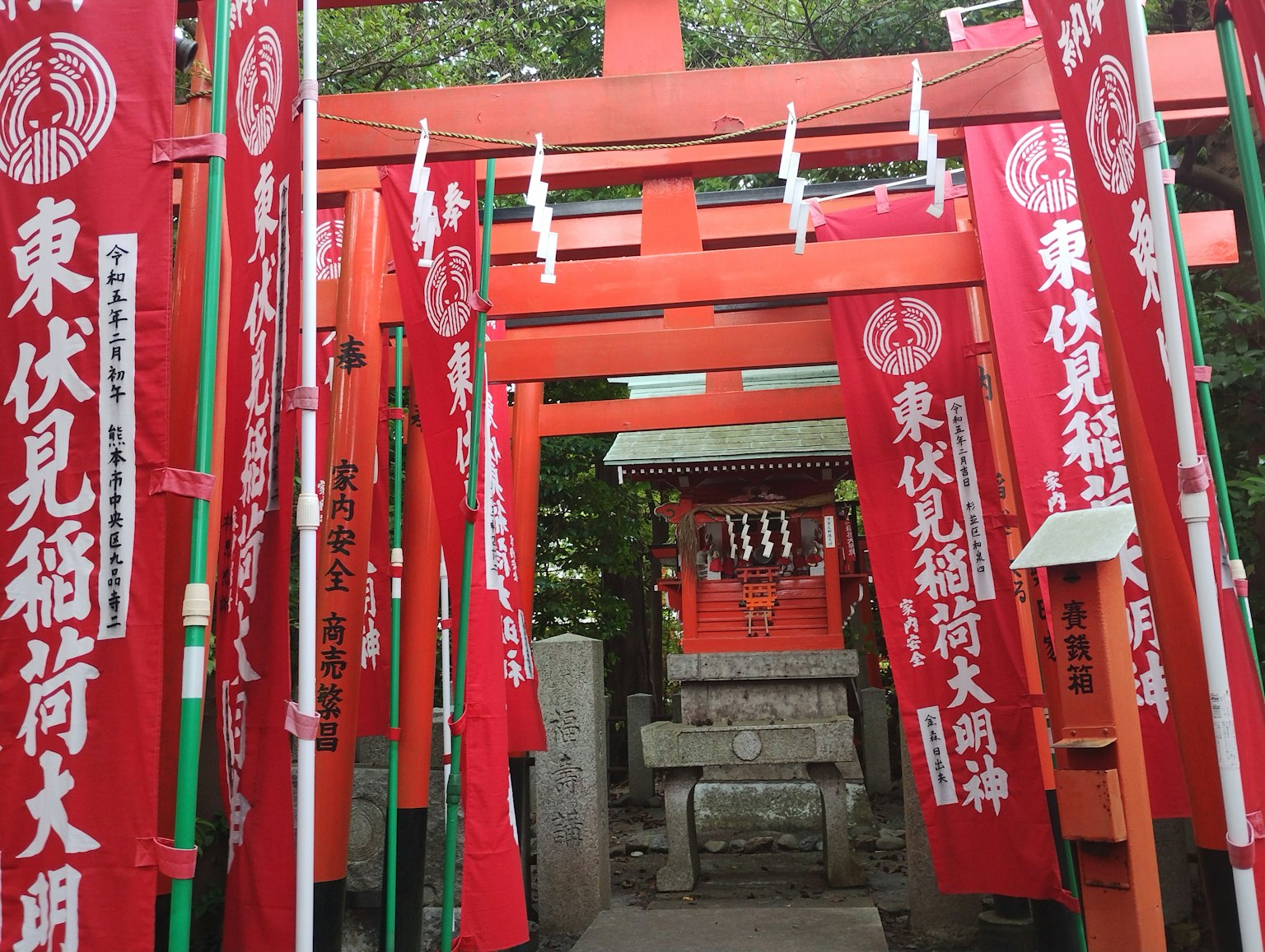 Entrata di un santuario con torii rossi e bandiere