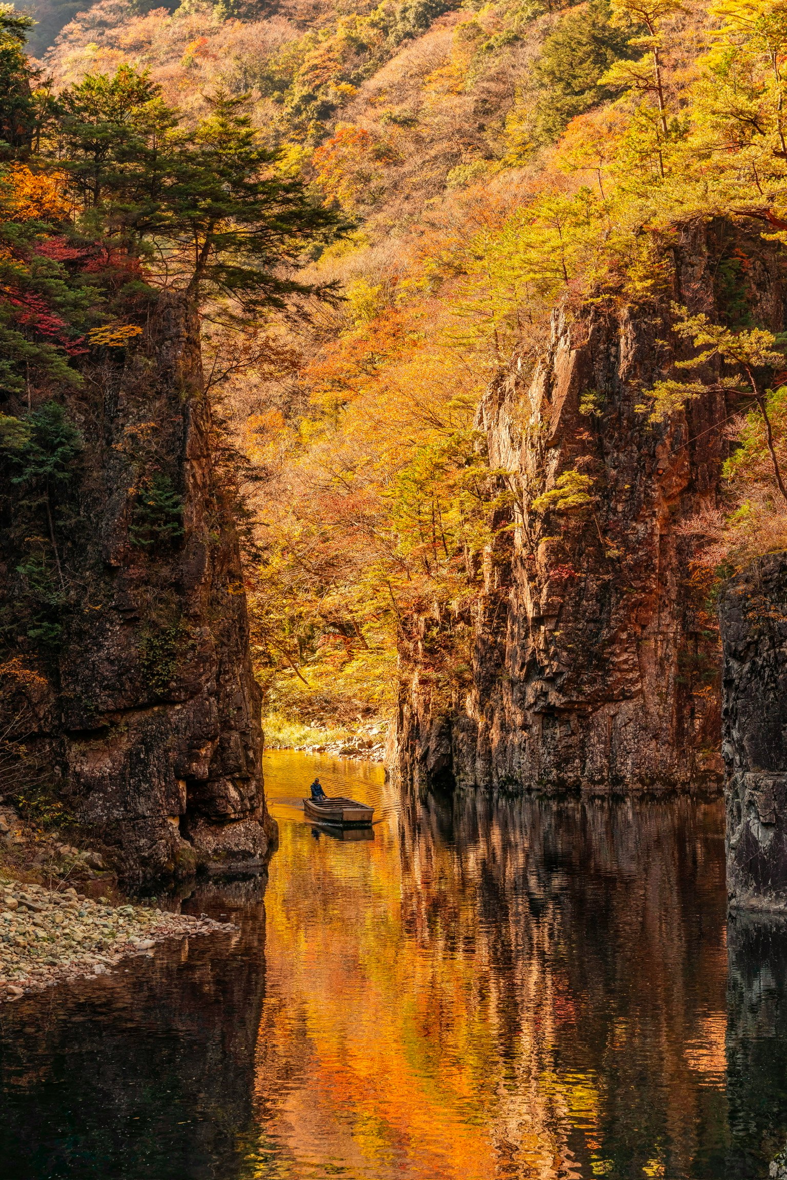 秋の色に染まった渓谷の景色 水面に映る紅葉と岩の形成