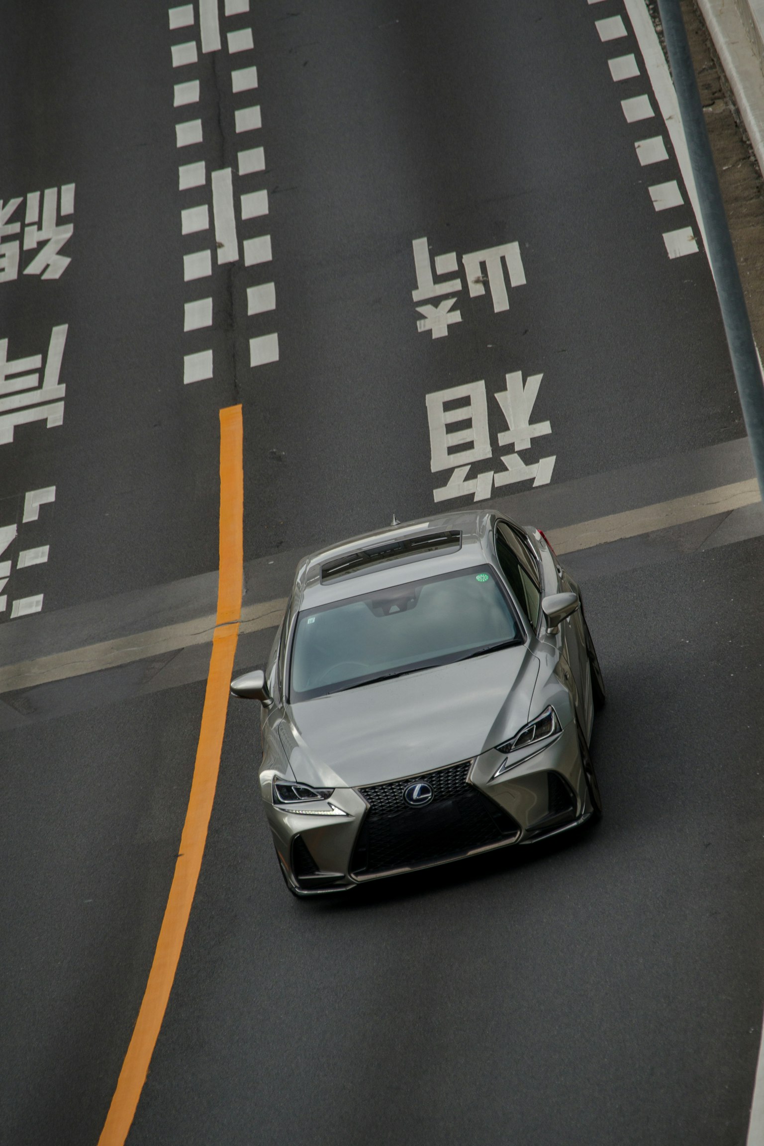 Lexus argento che svolta su una strada con segnaletica