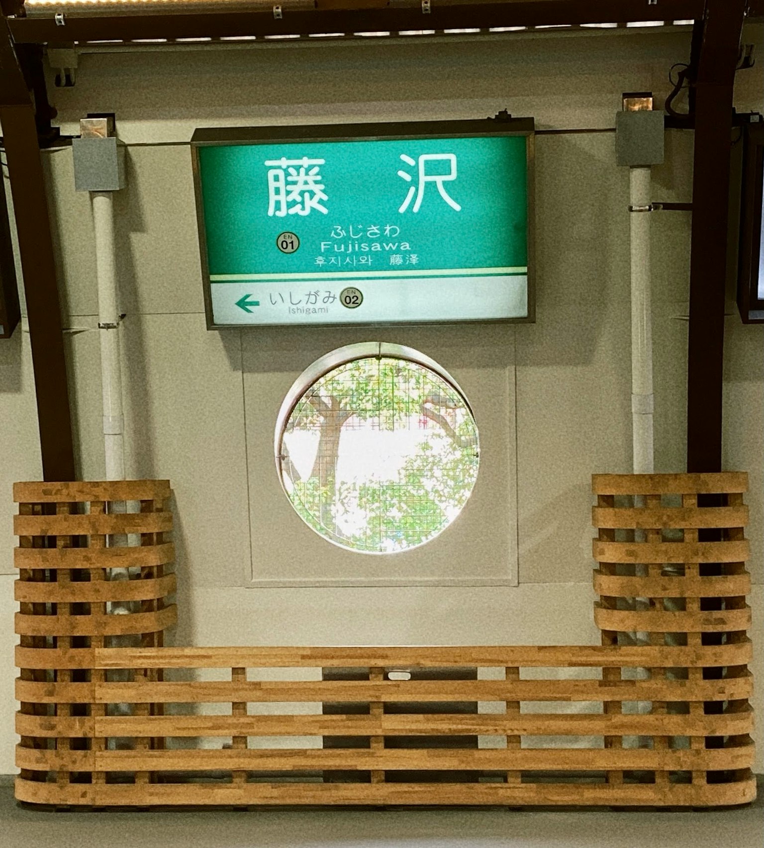 Papan stasiun Fujisawa dengan jendela bundar di platform