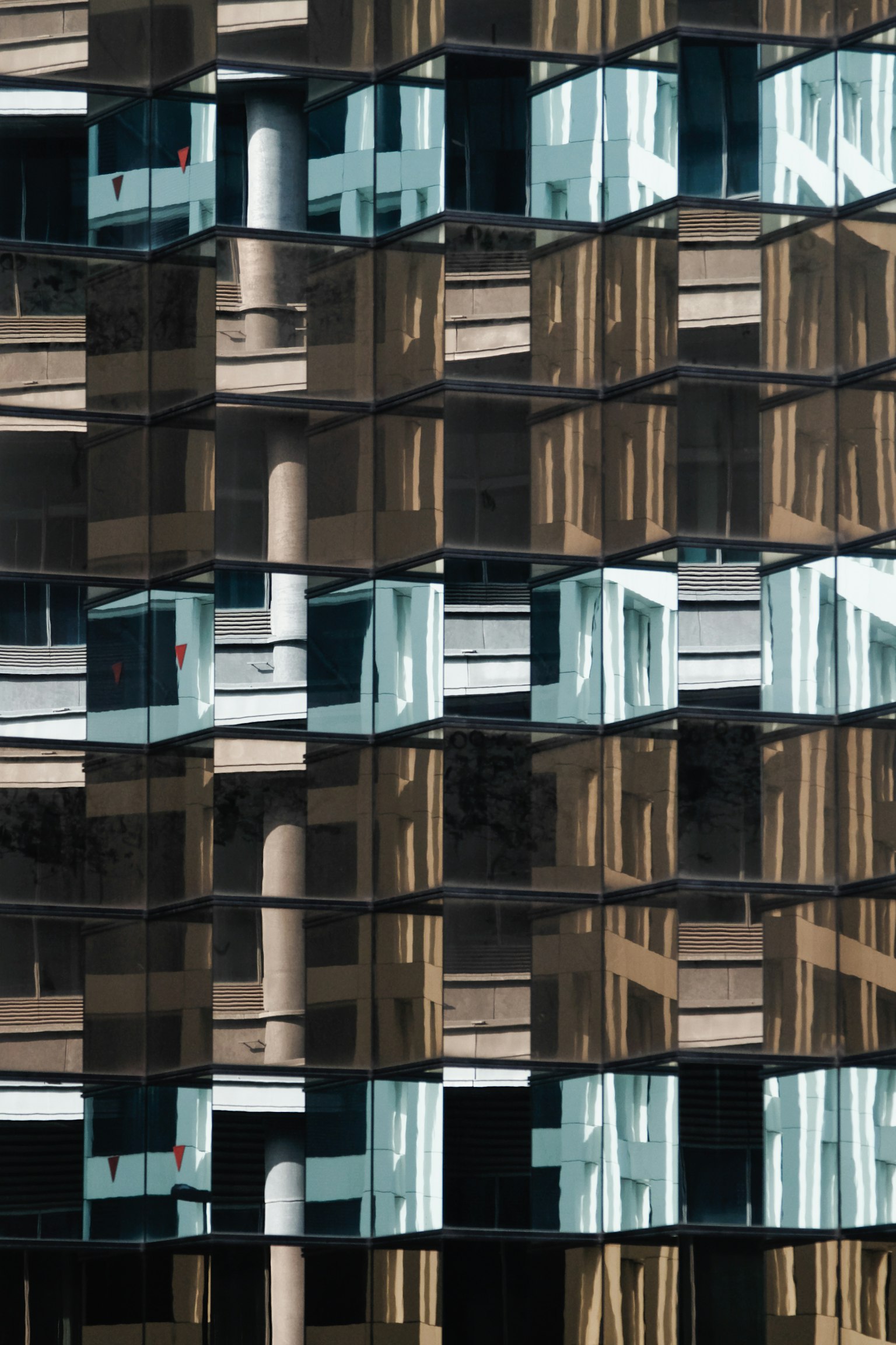 Façade d'un bâtiment moderne avec des reflets et des balcons en verre