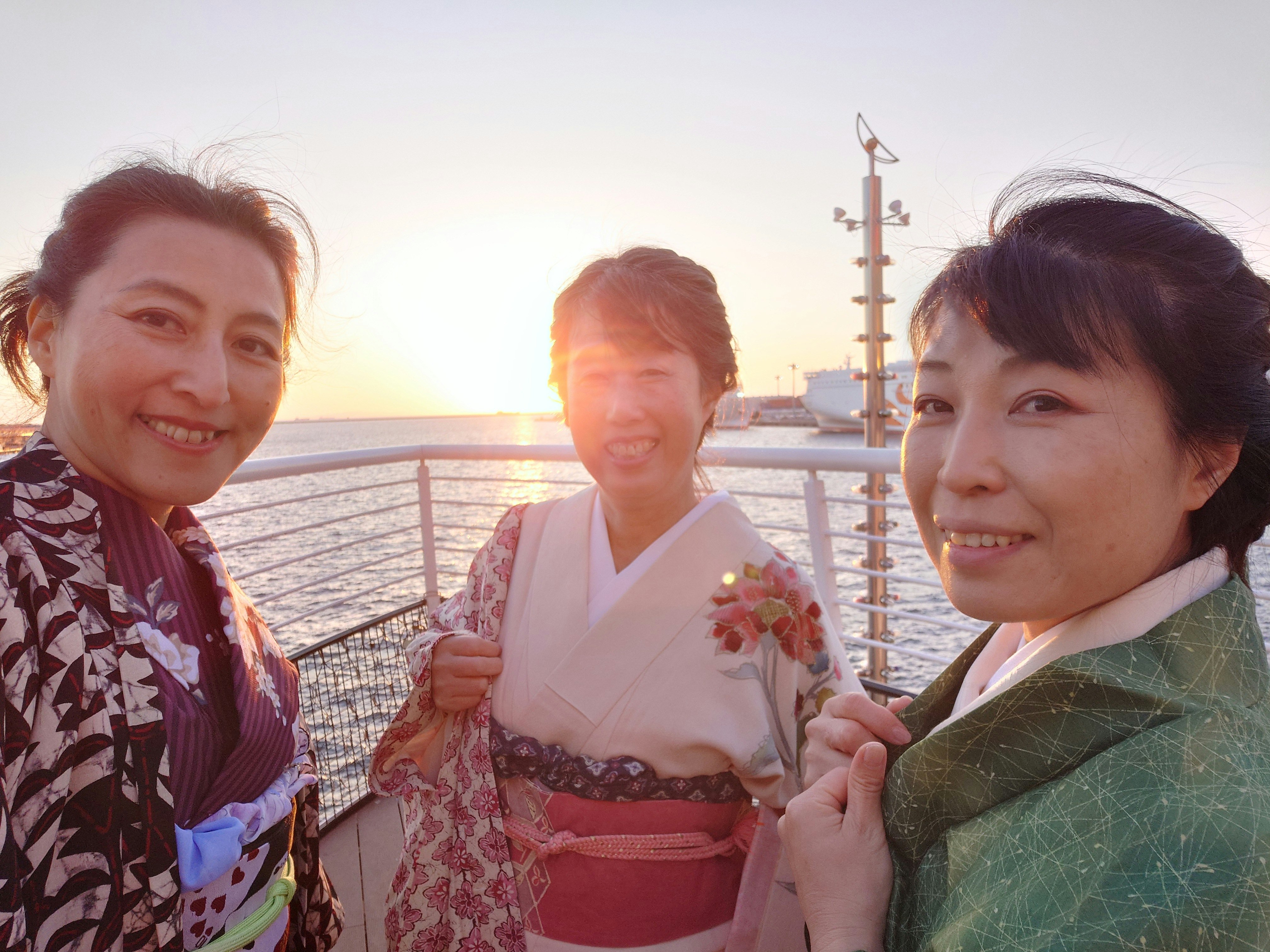 夕暮れの海辺で着物姿の女性たち