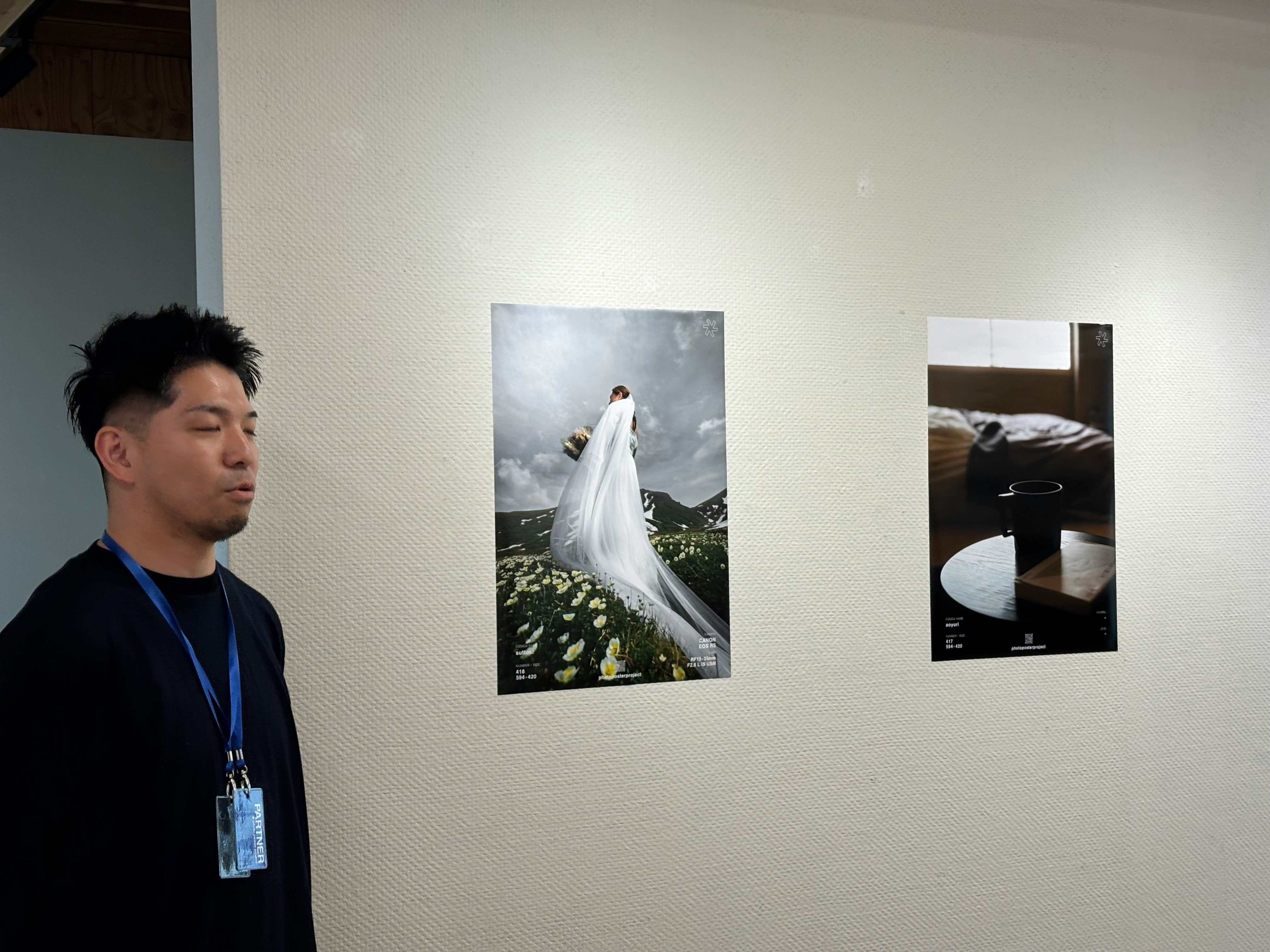 Visiteur devant des tirages photo accrochés sur un mur d’exposition