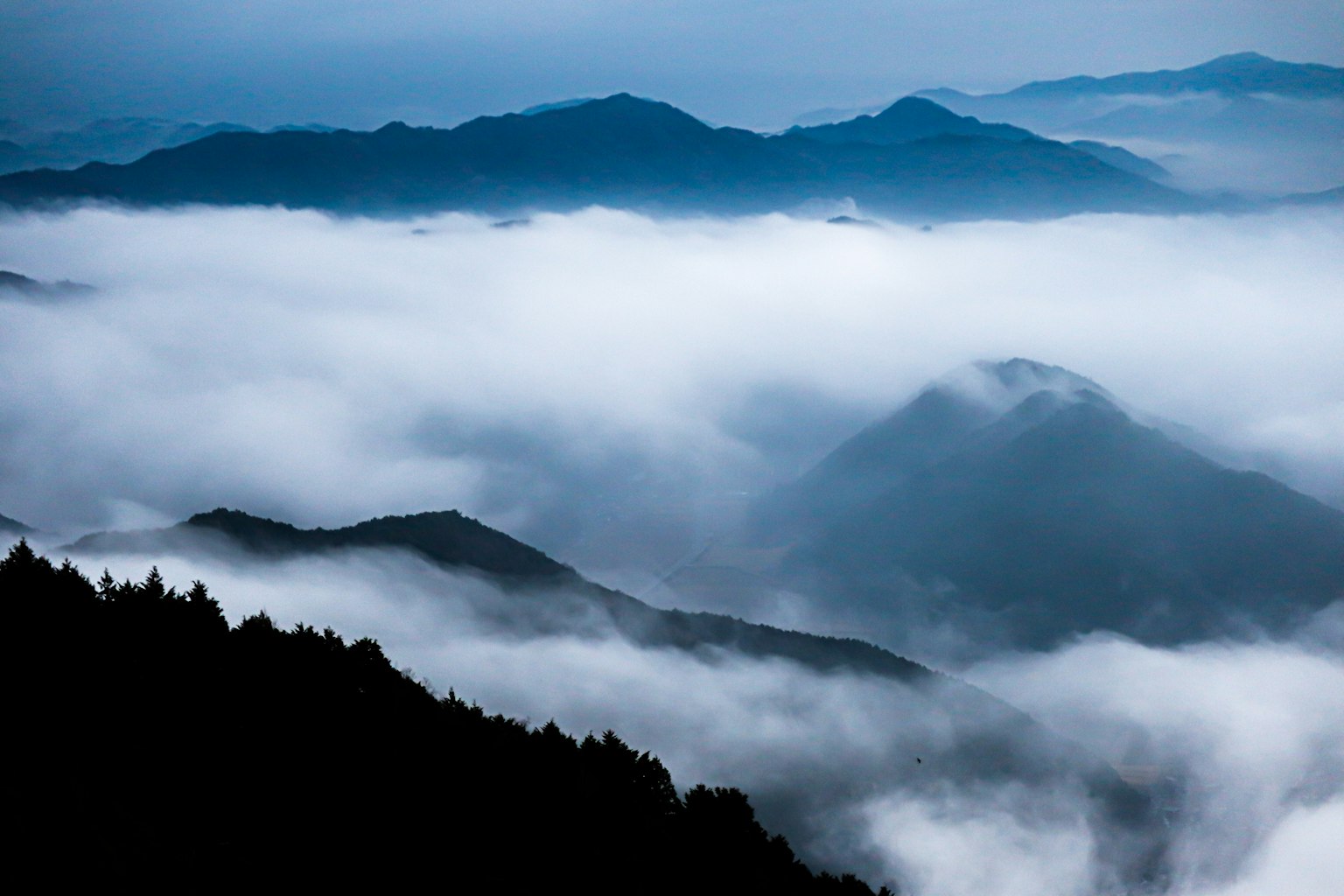 Paysage de montagnes enveloppées dans une brume bleue