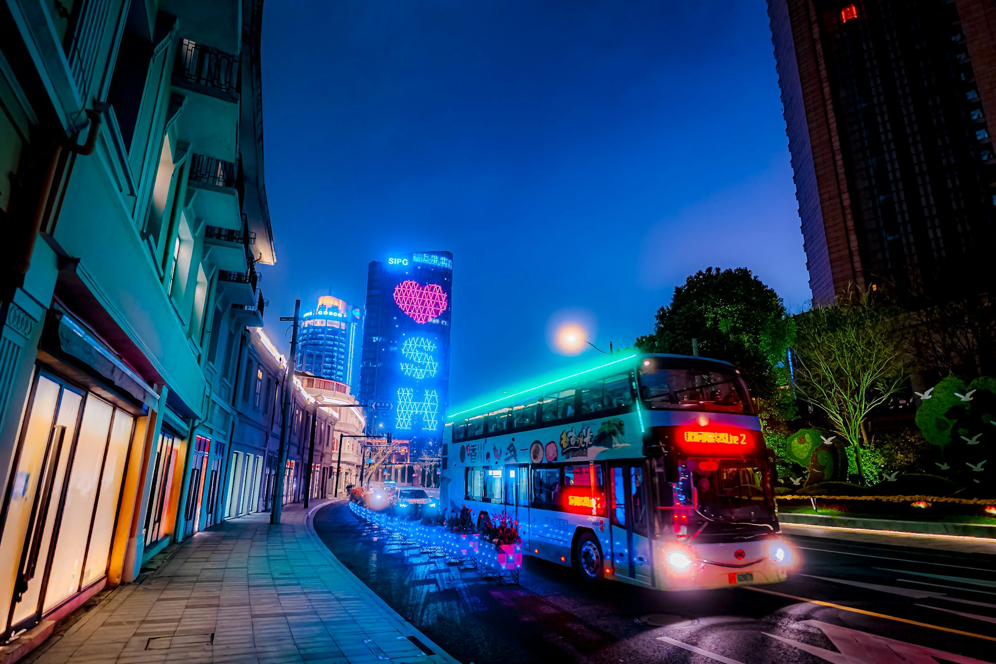 上海の夜の街並みと赤いバスが走る風景