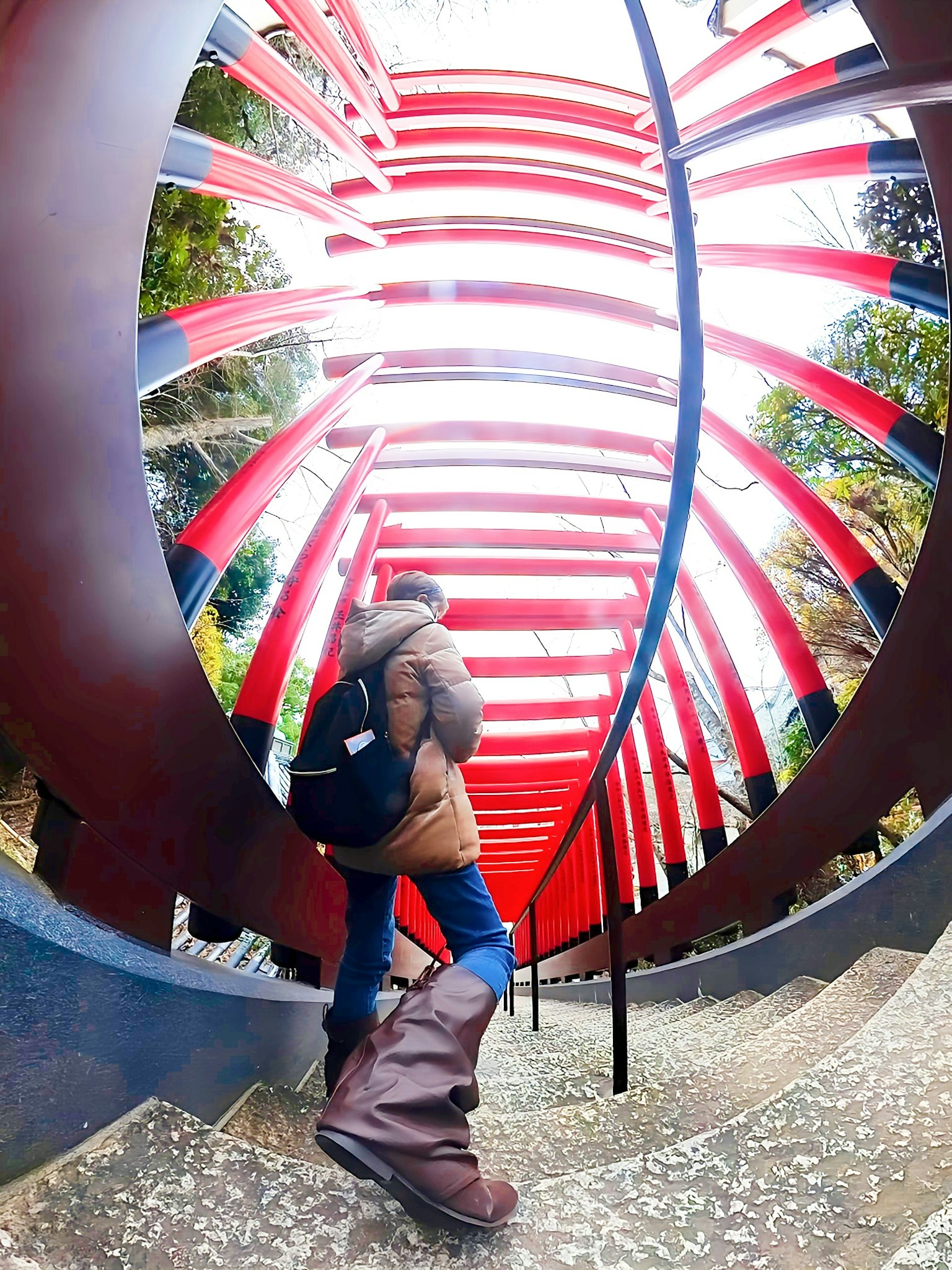 Une personne descendant des escaliers avec un tunnel rayé rouge en arrière-plan