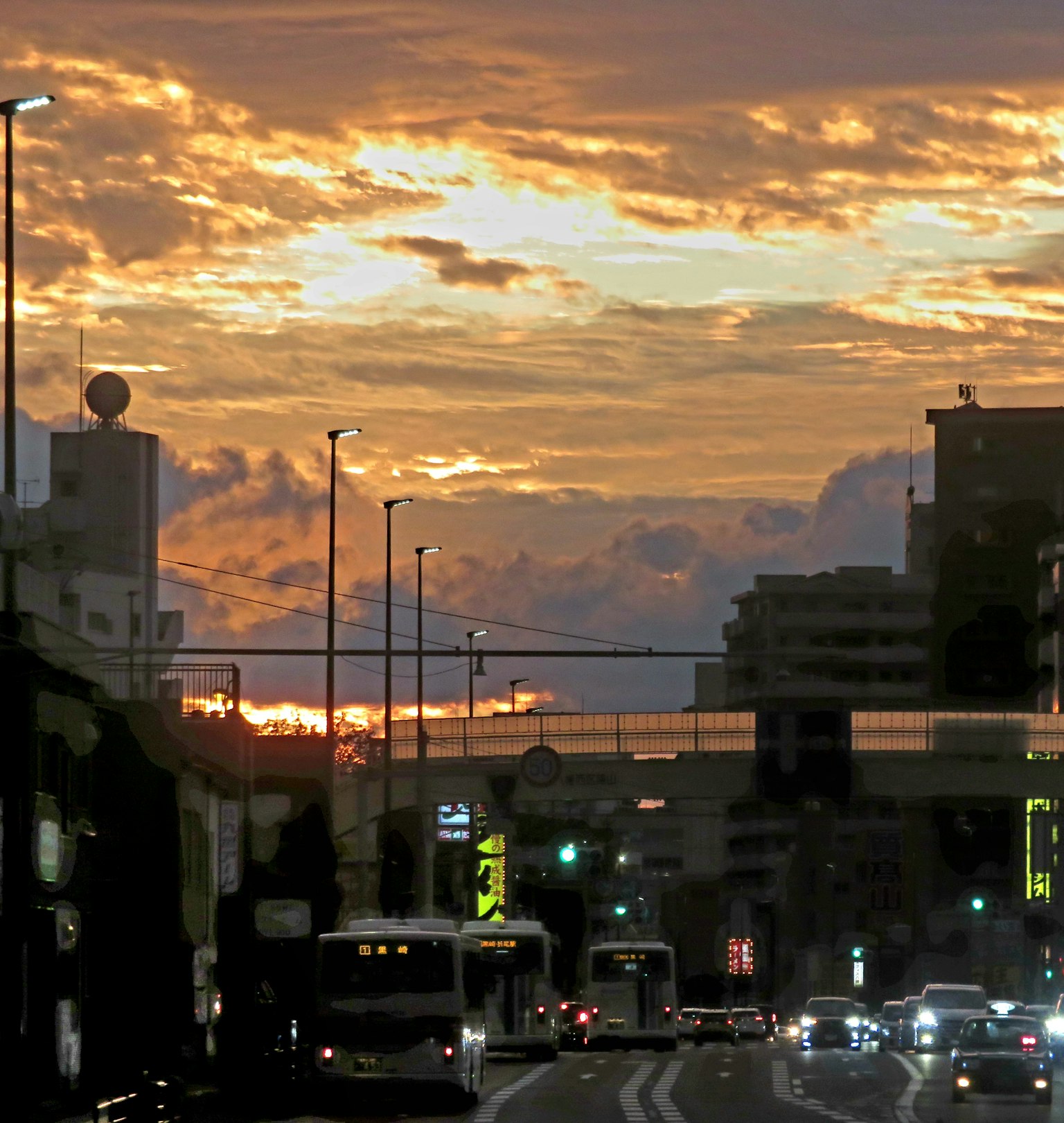 Städtische Landschaft bei Sonnenuntergang mit Blick auf die Straße und Verkehrsampeln