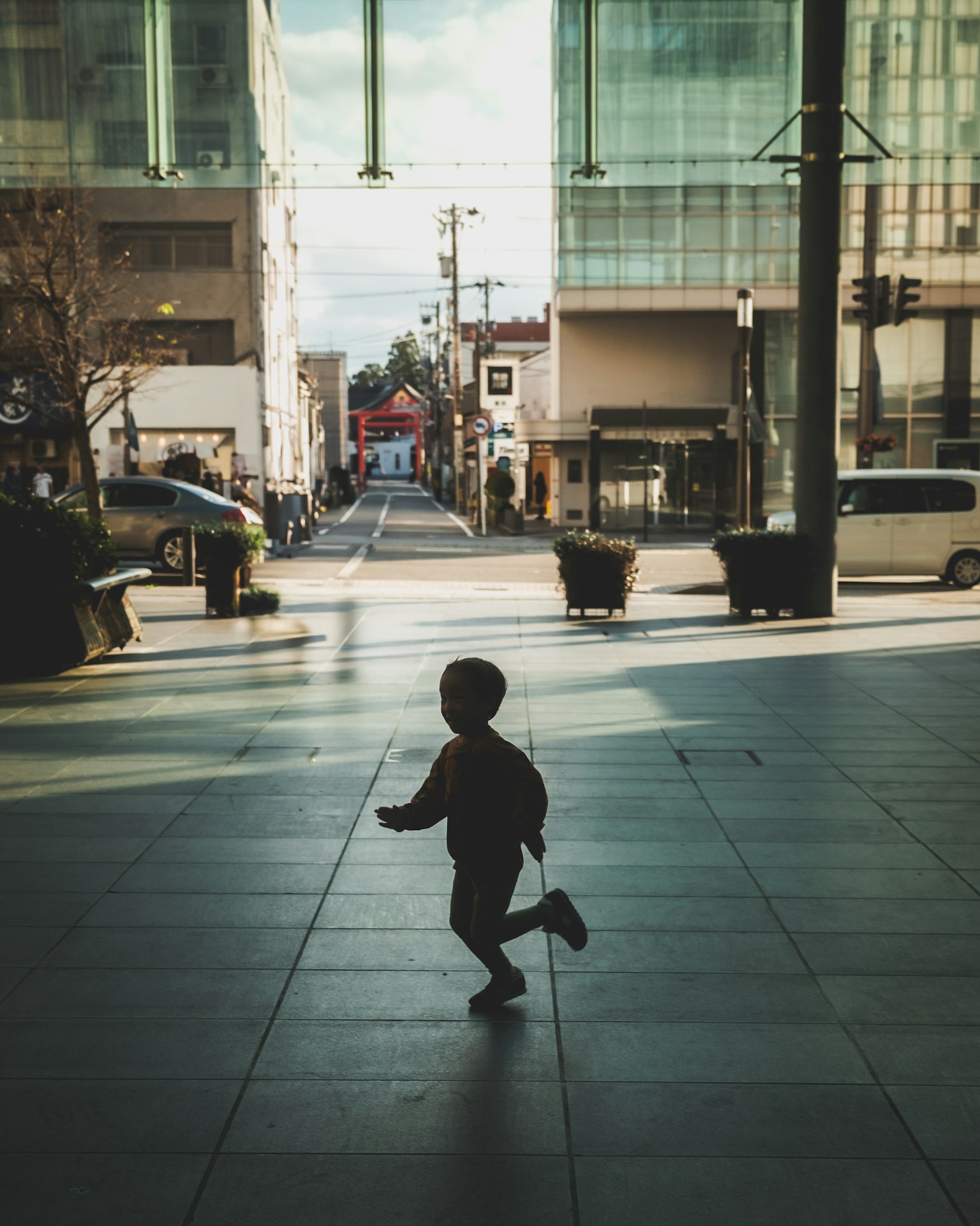 Niño corriendo en un paisaje urbano con edificios y calles visibles