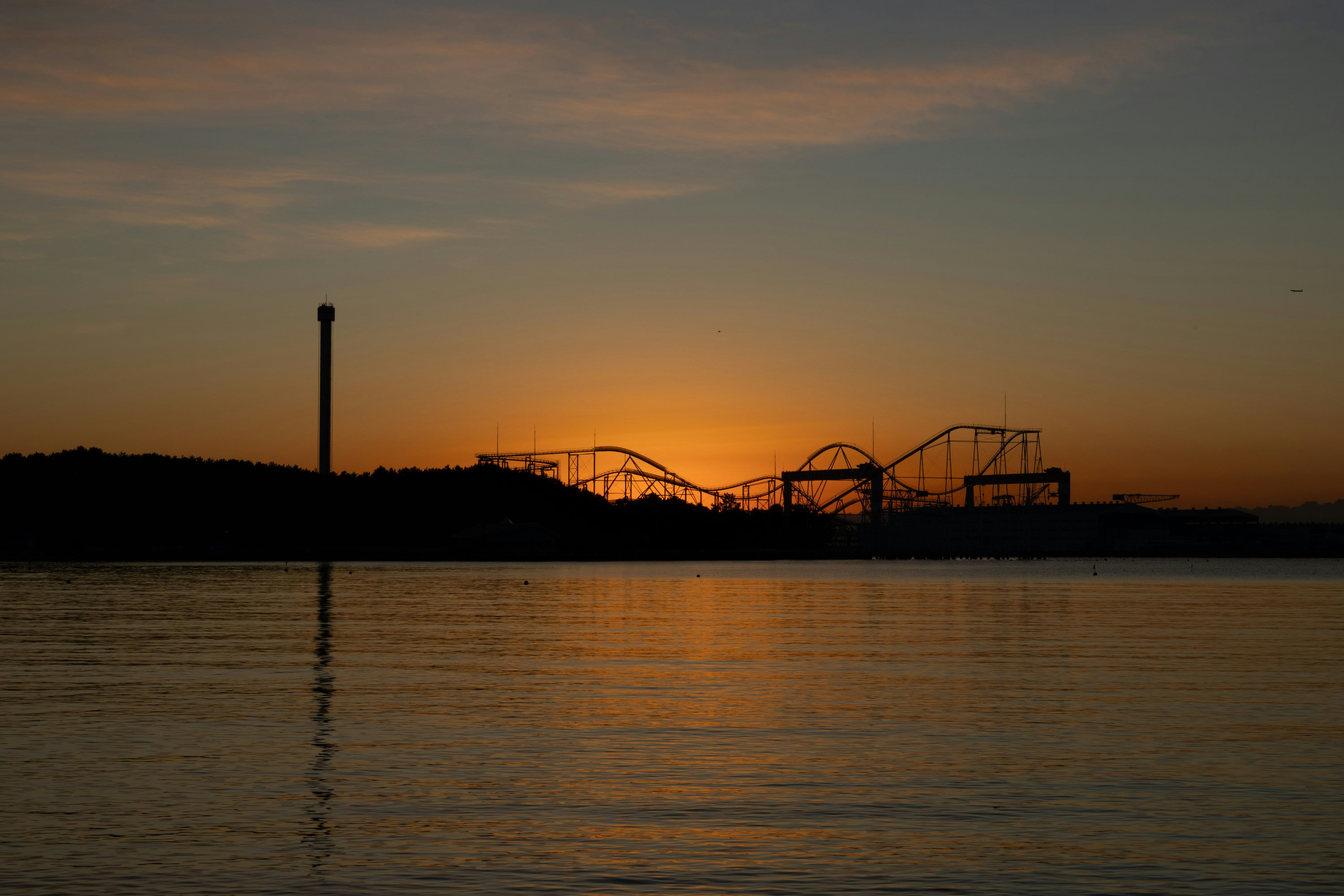 夕暮れの湖面と遊園地の観覧車のシルエット