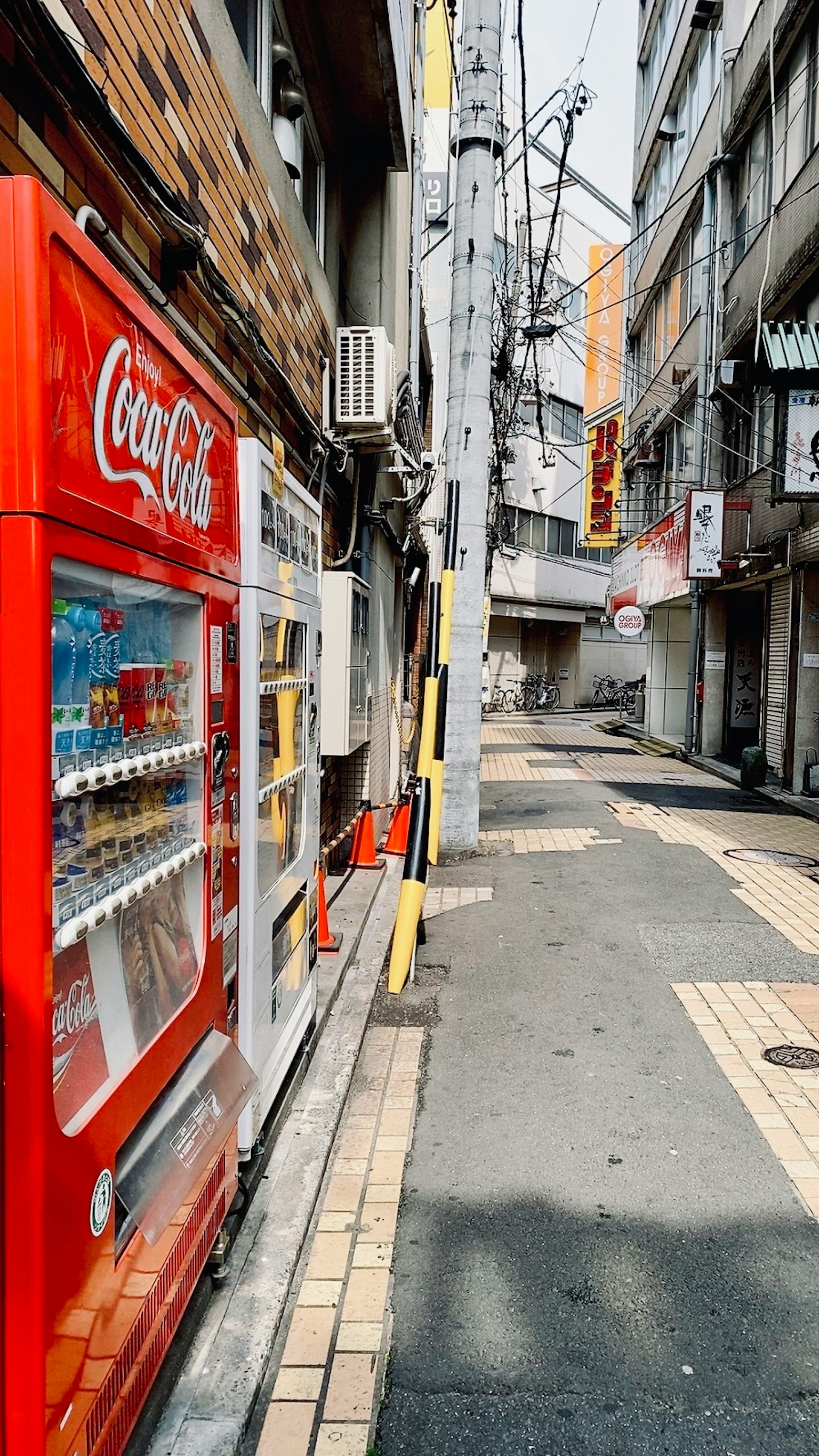 Vicolo stretto con un distributore automatico Coca-Cola e edifici circostanti