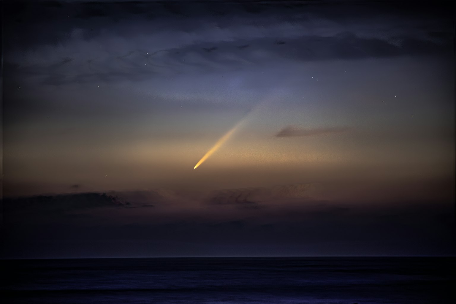 Una coda di cometa che brilla sopra l'oceano al crepuscolo con stelle nel cielo