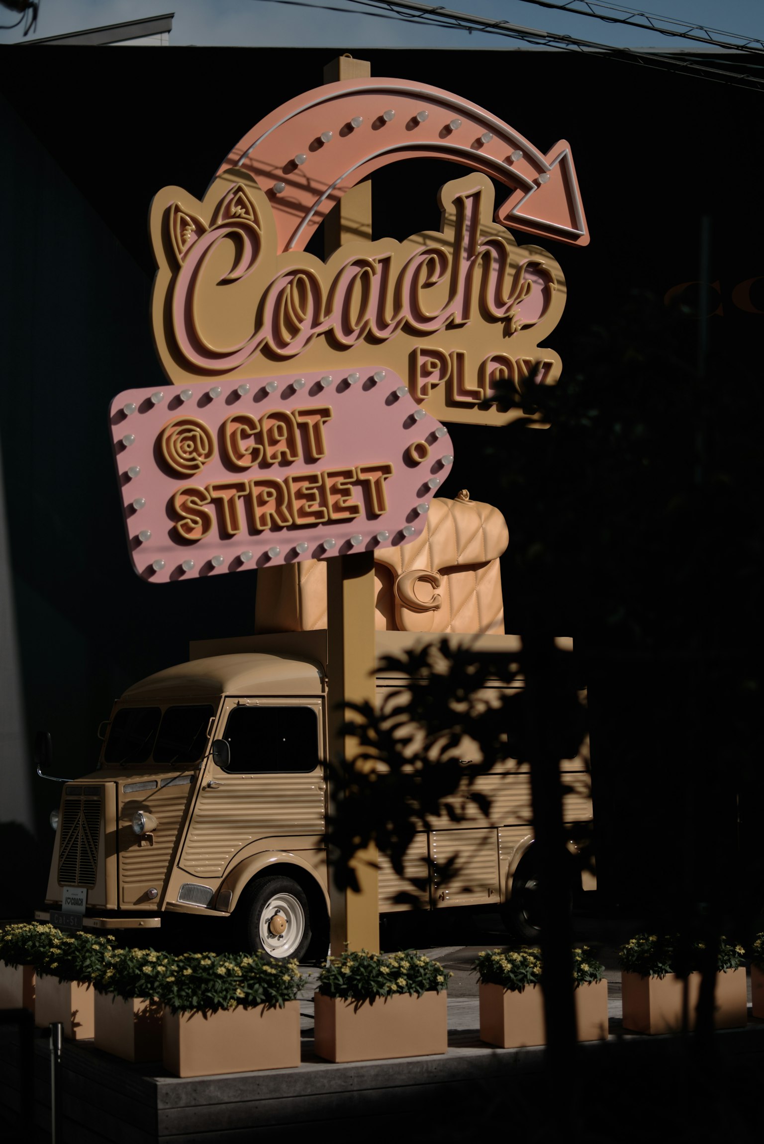 Sign for Coach Plaza featuring a small truck display on Cat Street