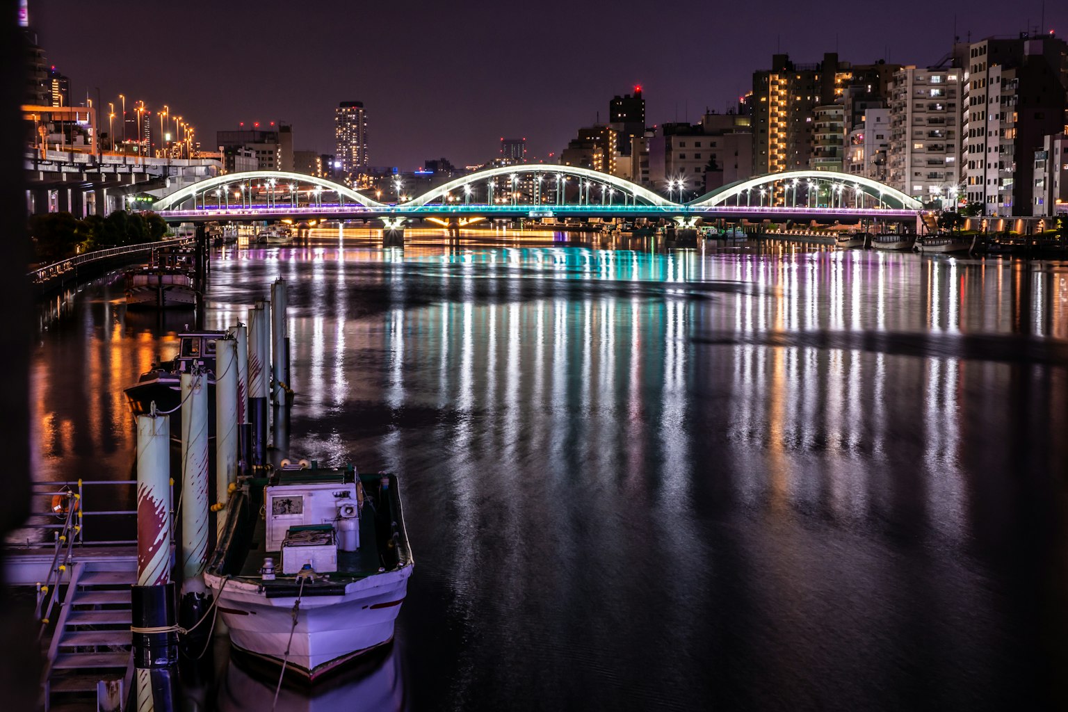 Beautiful arch bridge over a river at night with reflections on the water
