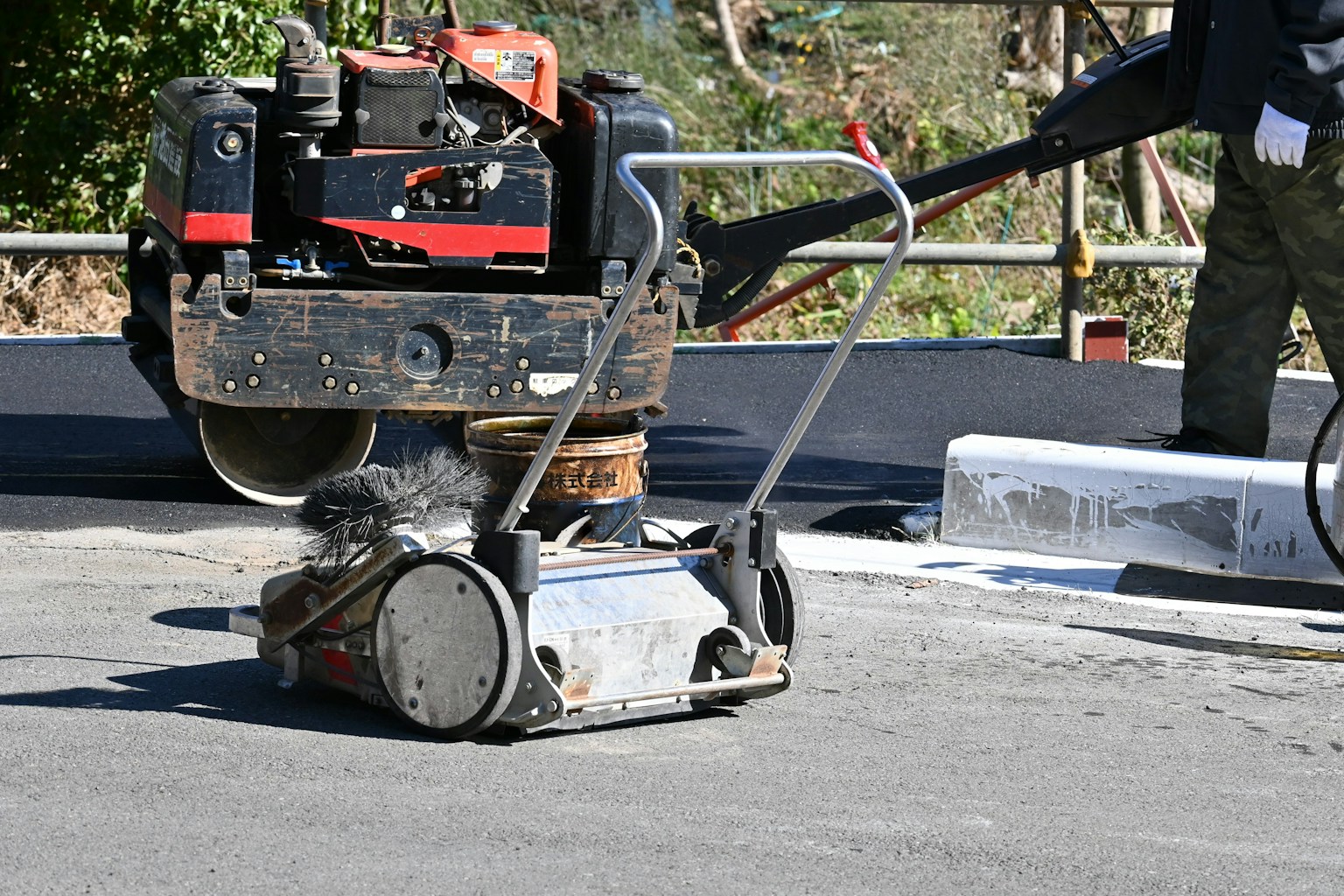 Construction scene featuring a roller and machinery on pavement