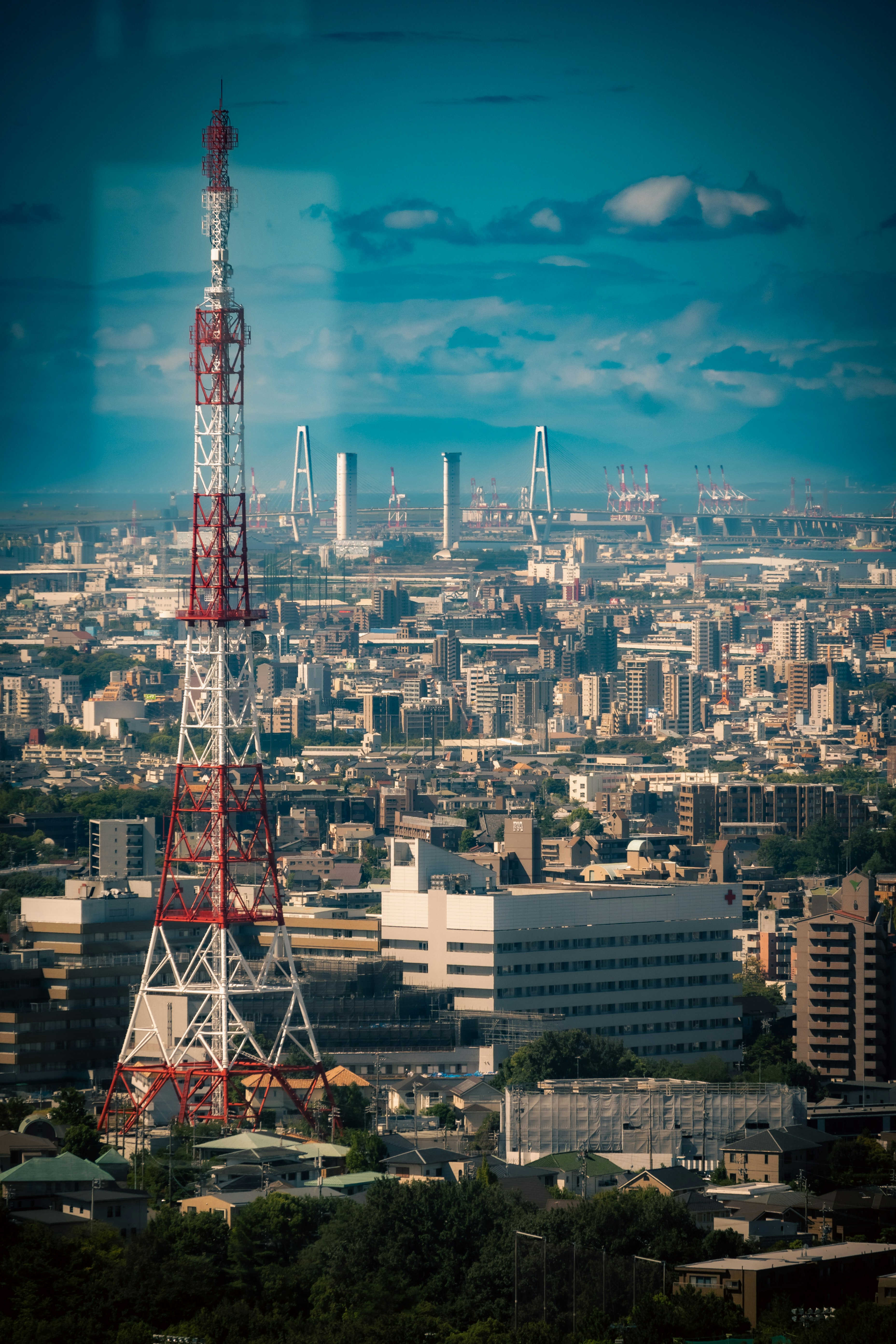 城市天際線中高聳的廣播塔與工業區景觀