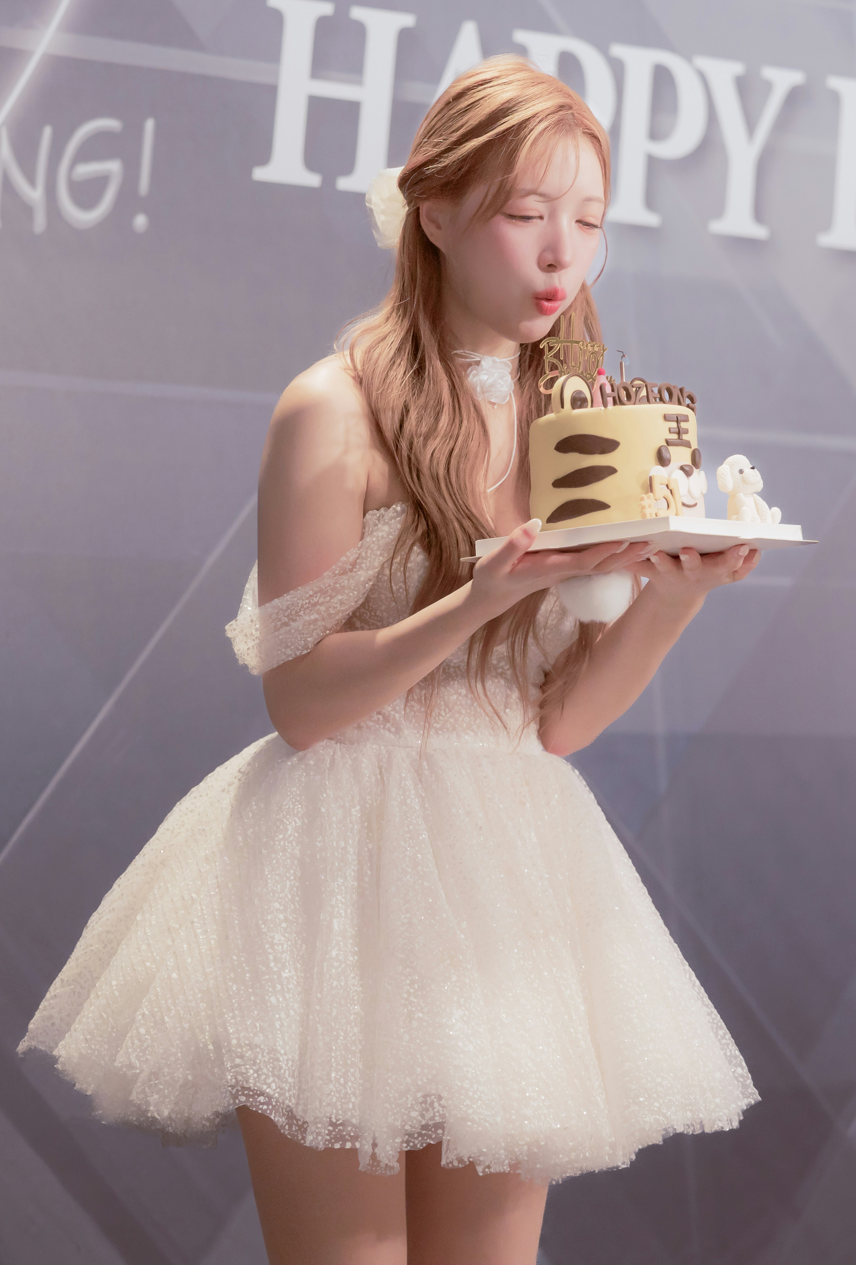 バースデーケーキを見つめるチアリーダーの女性