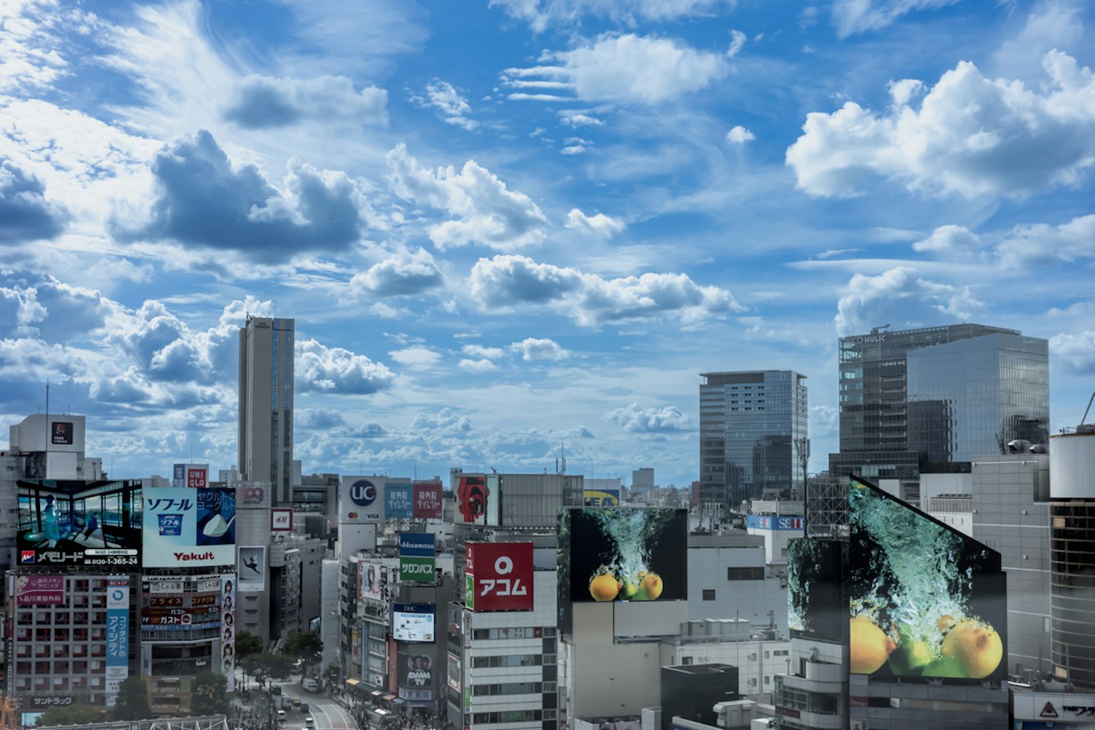 Panorama urbano con cielo blu e nuvole che mostrano edifici e pubblicità