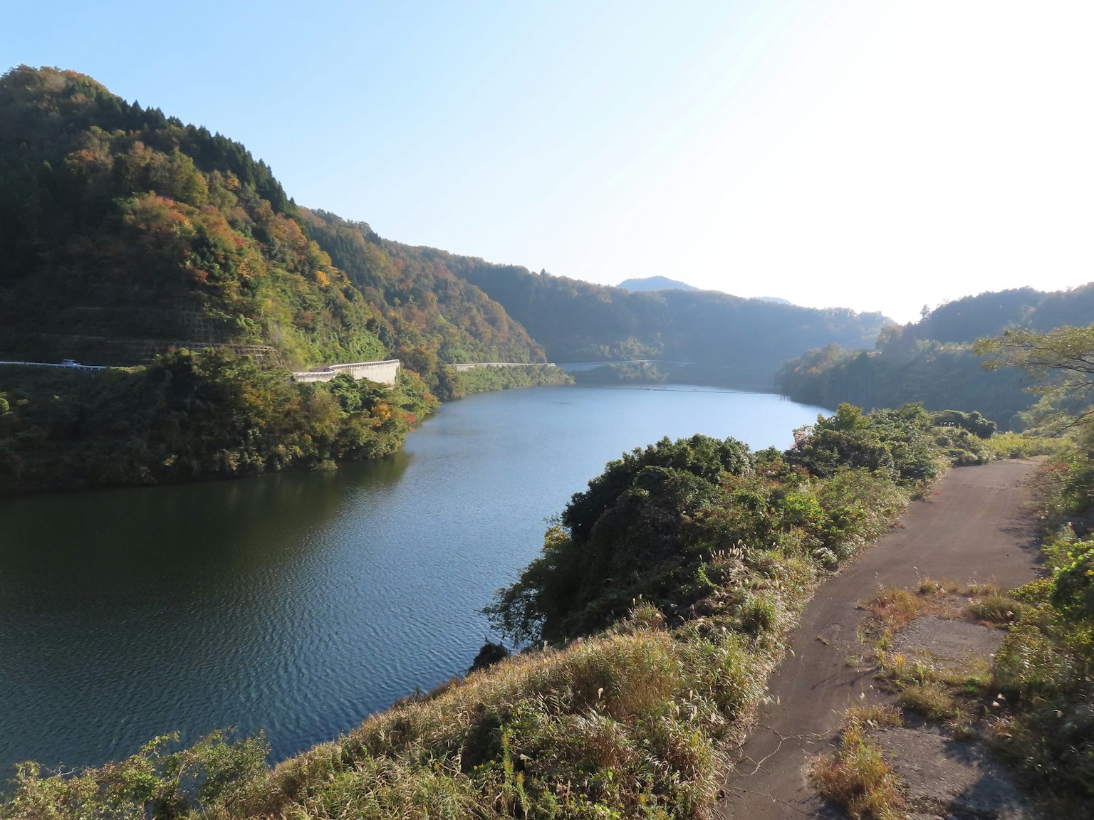 Vue pittoresque d'une rivière entourée de montagnes sous un ciel dégagé et des couleurs d'automne