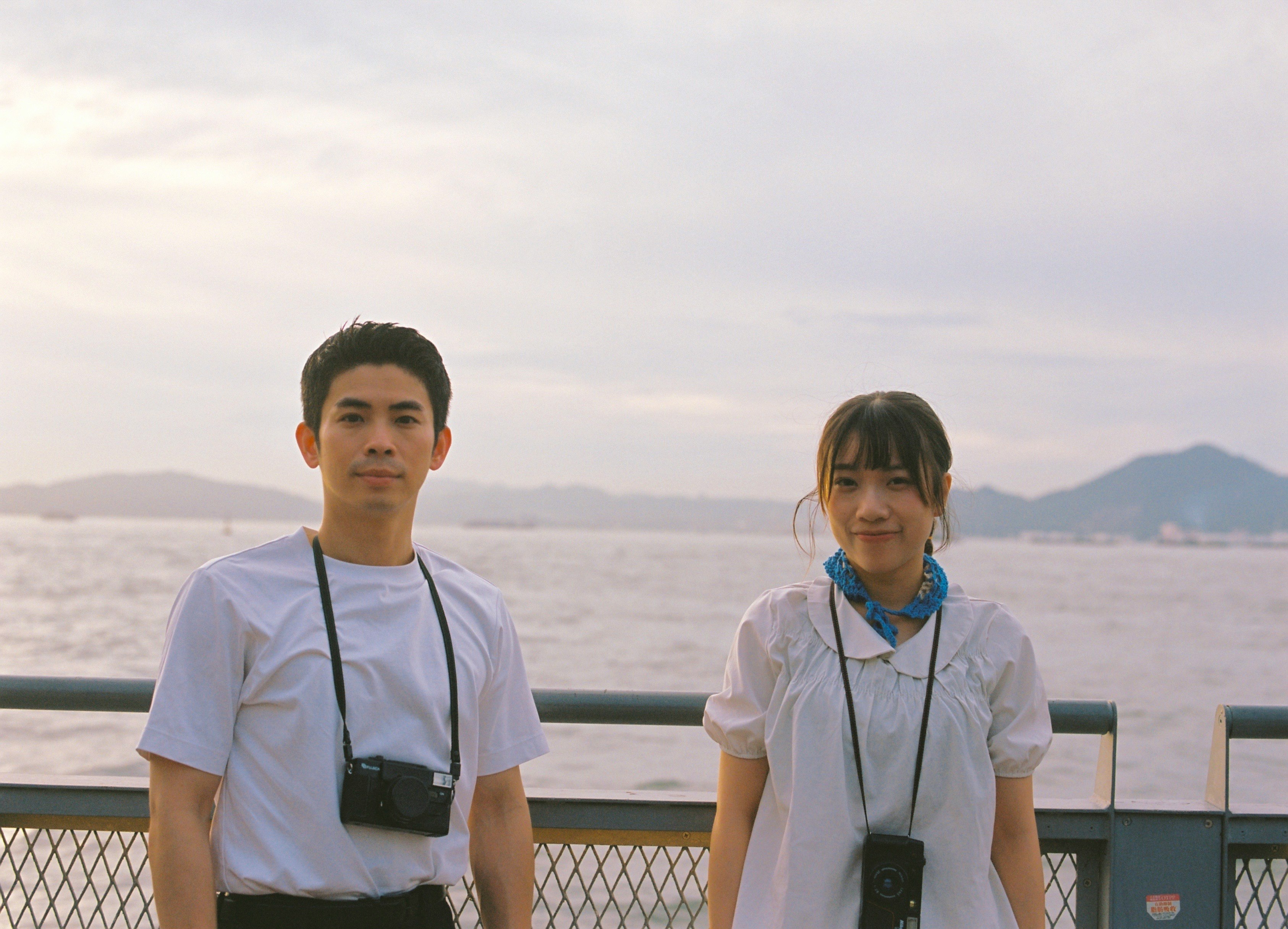 海辺の展望デッキで並ぶ2人のスタッフ