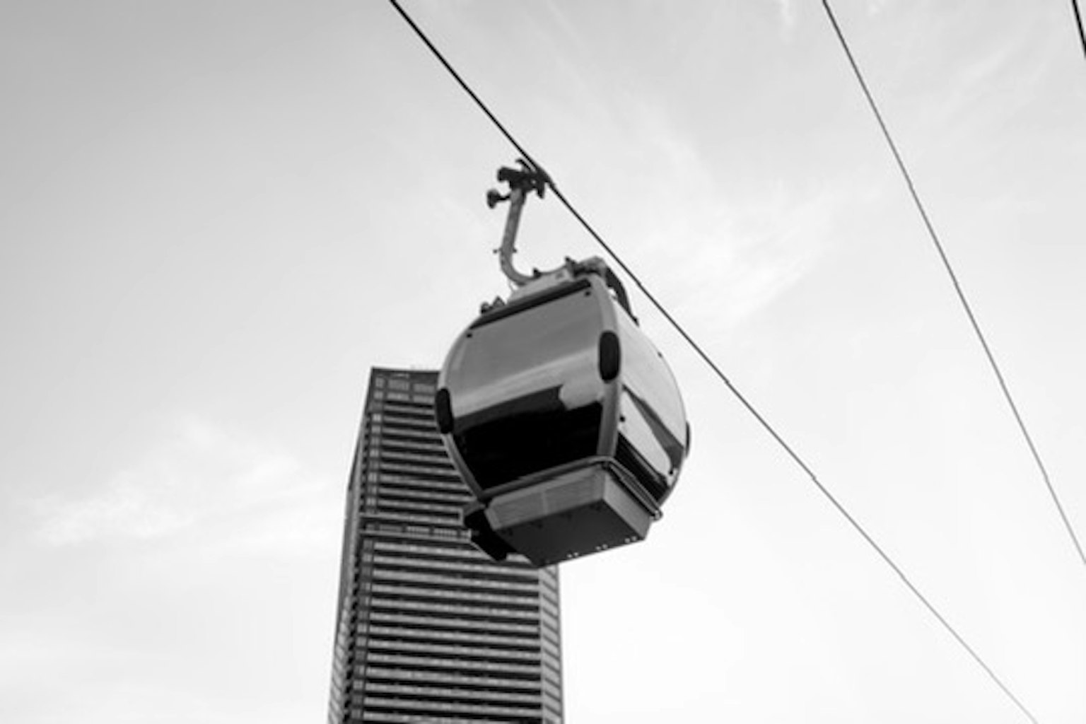 Un teleférico pasando sobre un rascacielos