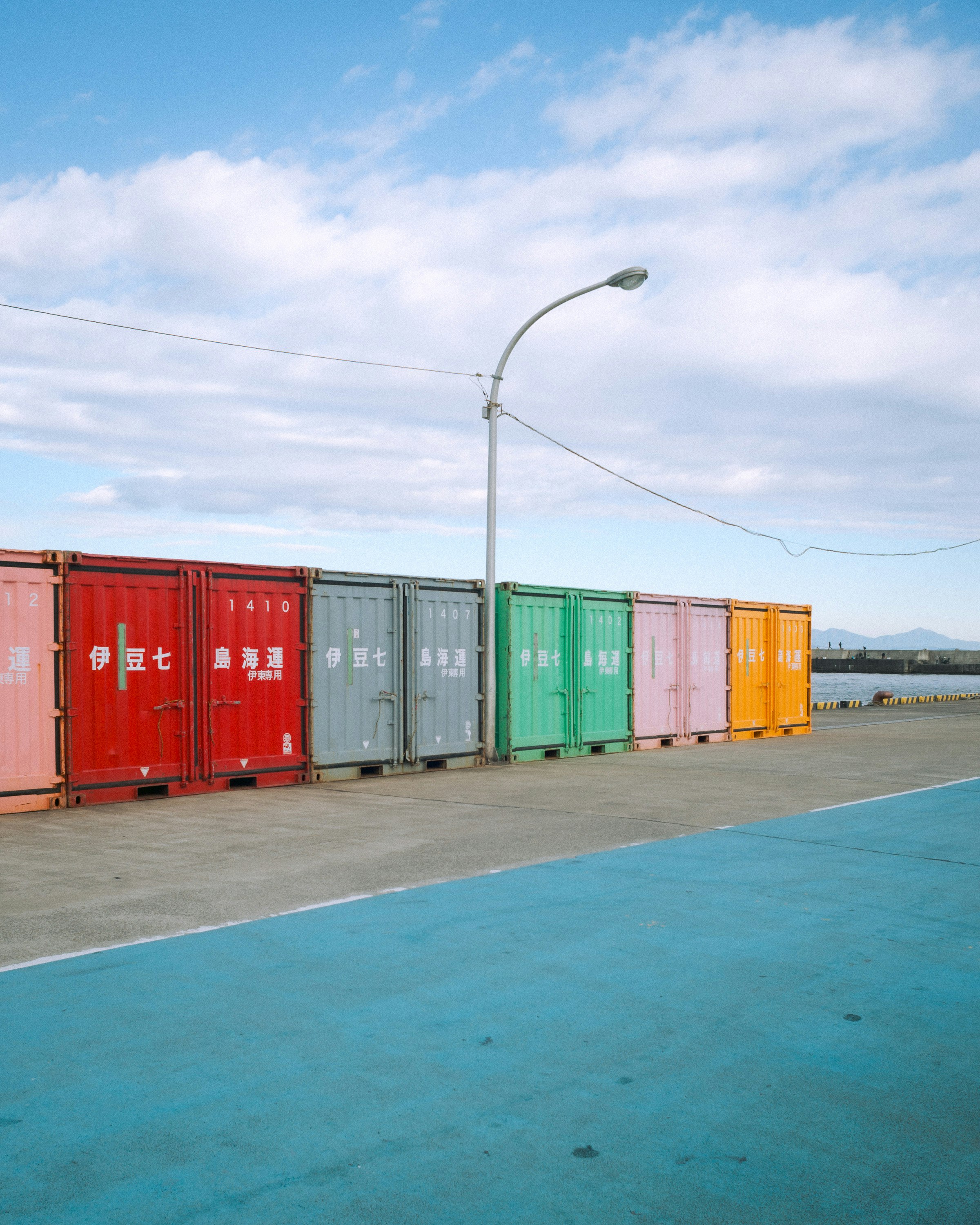Corridoio in un piazzale portuale con container e pavimento blu
