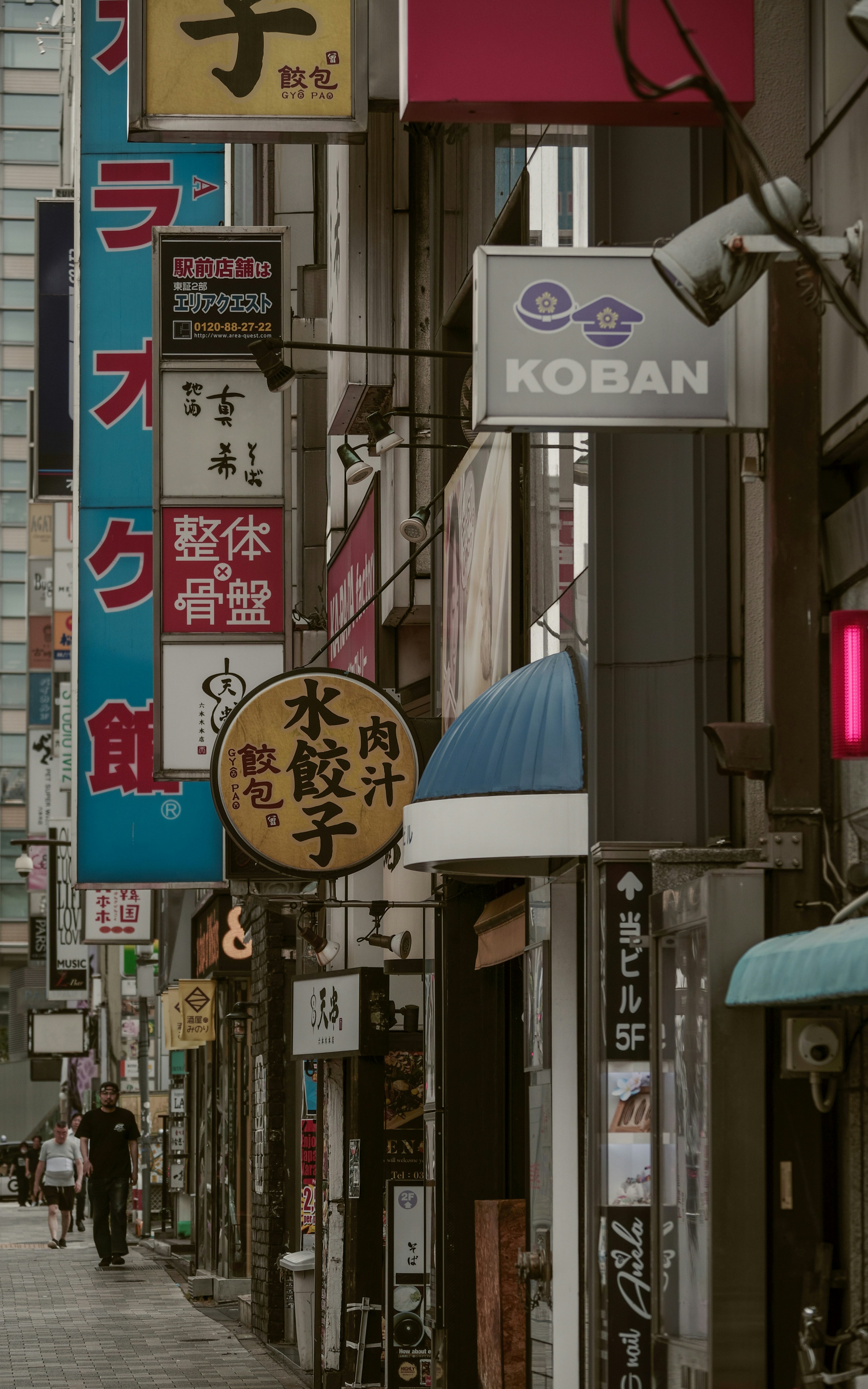 路地に並ぶ看板と飲食店の軒先