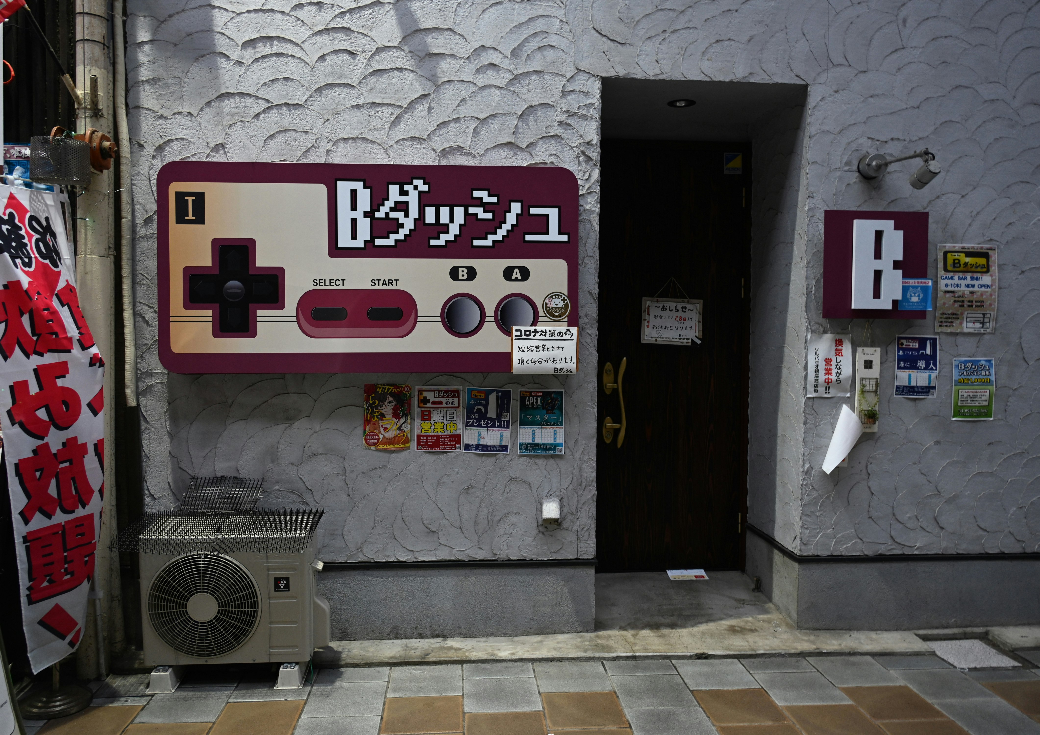 狹窄巷弄牆上的復古街機遊戲機與資訊面板