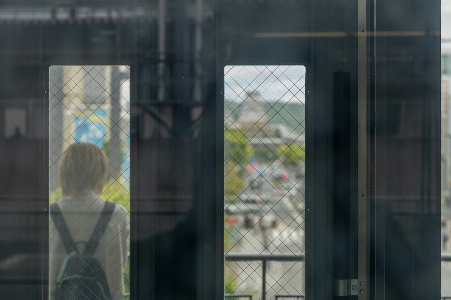 Persona mirando por la ventana de un tren con vista a la ciudad