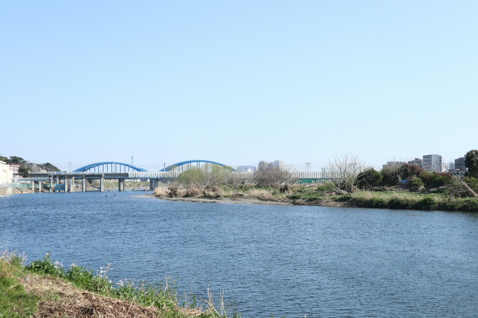 Scenic river view with a bridge under a clear blue sky