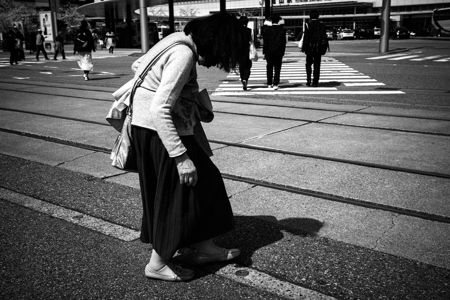 Una mujer mirando al suelo descalza en una foto en blanco y negro