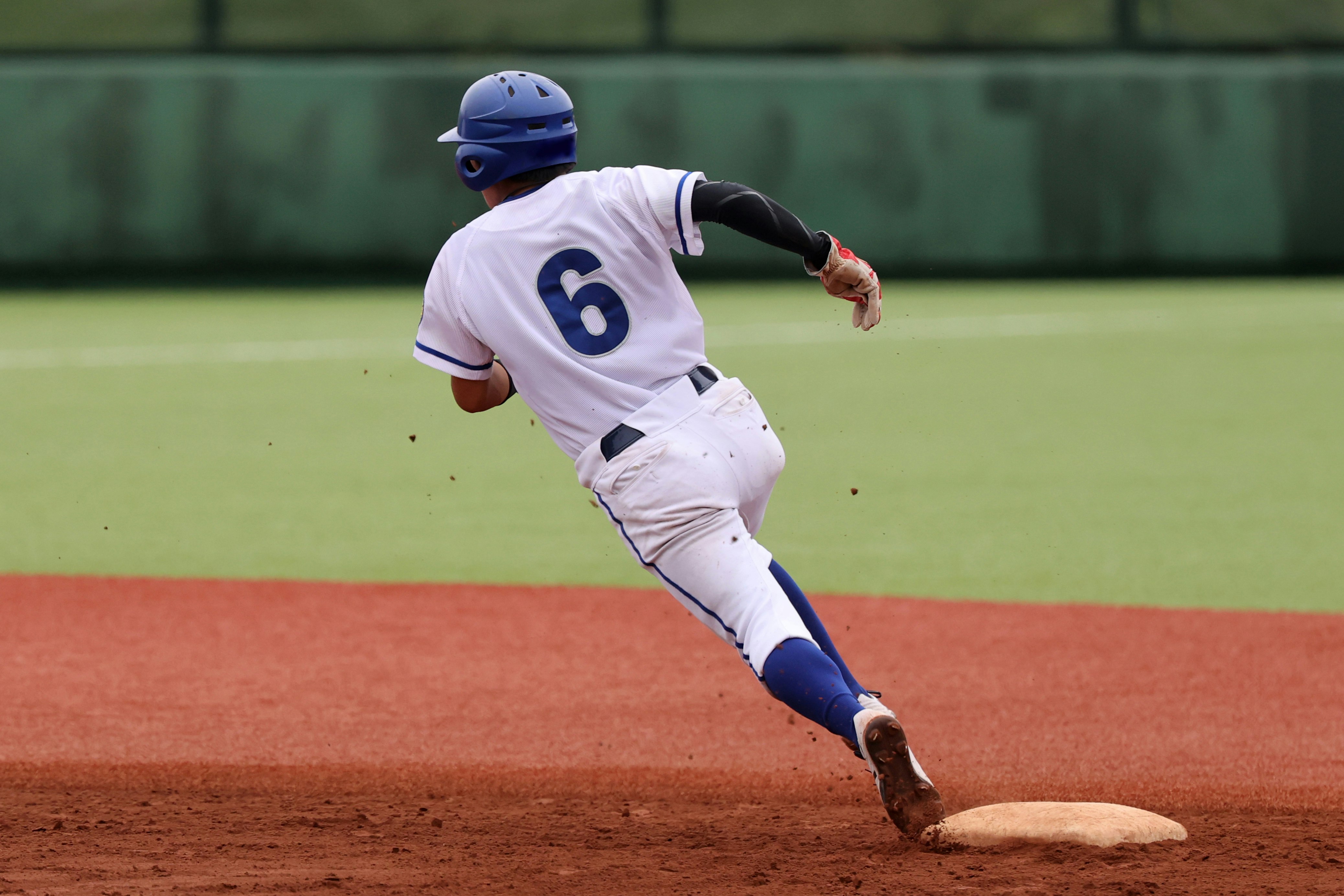 野球場で守備の投球フォームを見せる背番号6の選手