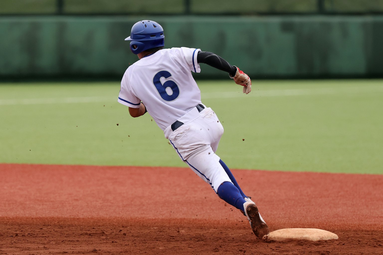 Joueur de baseball courant vers la deuxième base portant le numéro 6