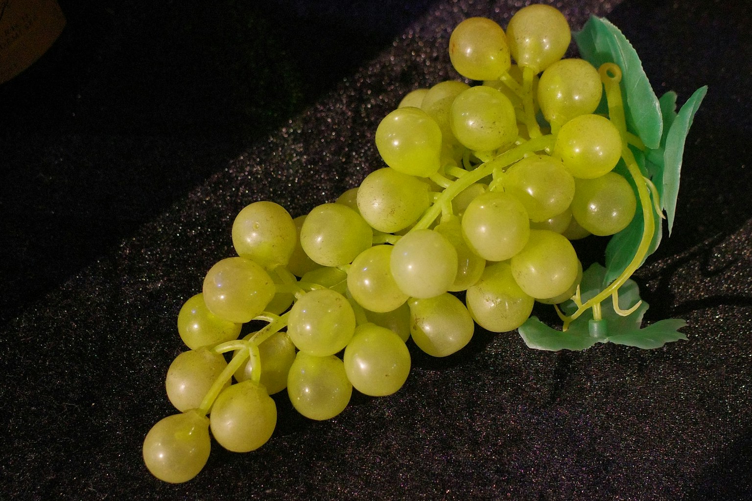 緑色のブドウの房が黒い背景に置かれている