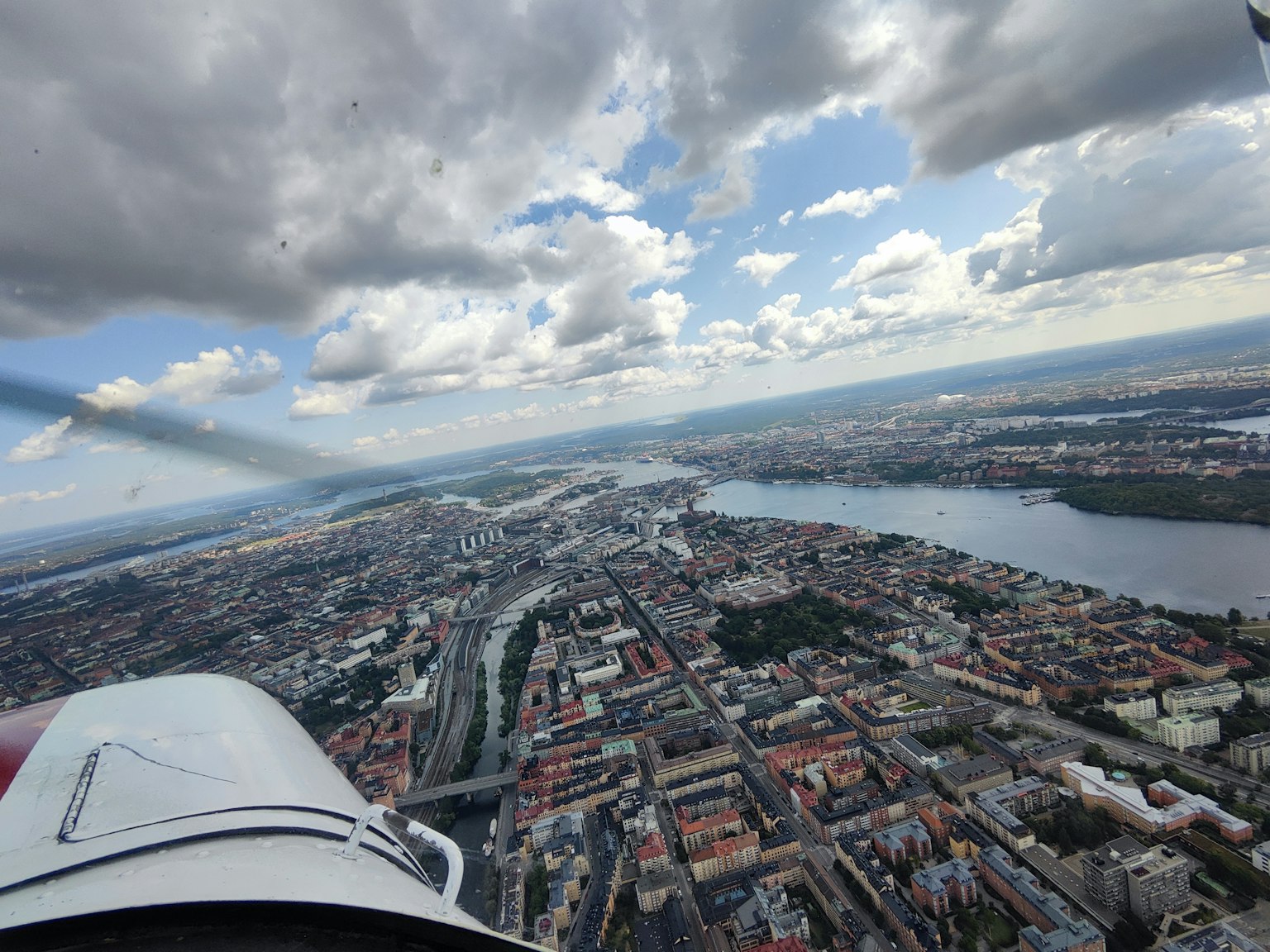 Vue aérienne d'une ville depuis un avion montrant une rivière et des nuages