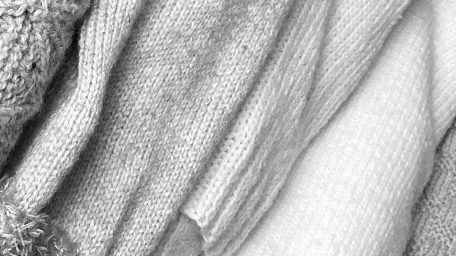 Textures of overlapping white and gray knit fabrics