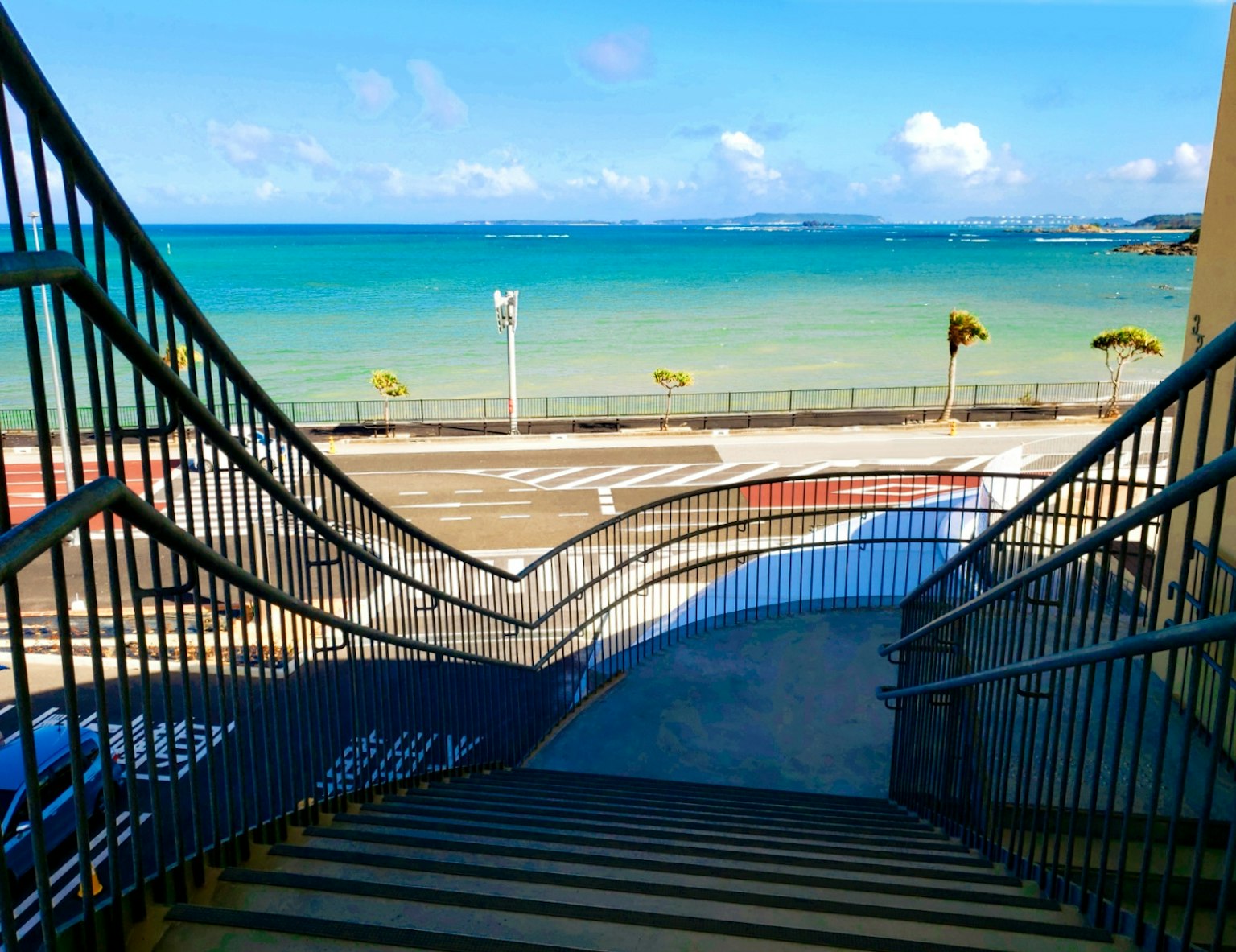 通往海滩的楼梯，海水碧蓝，天空湛蓝