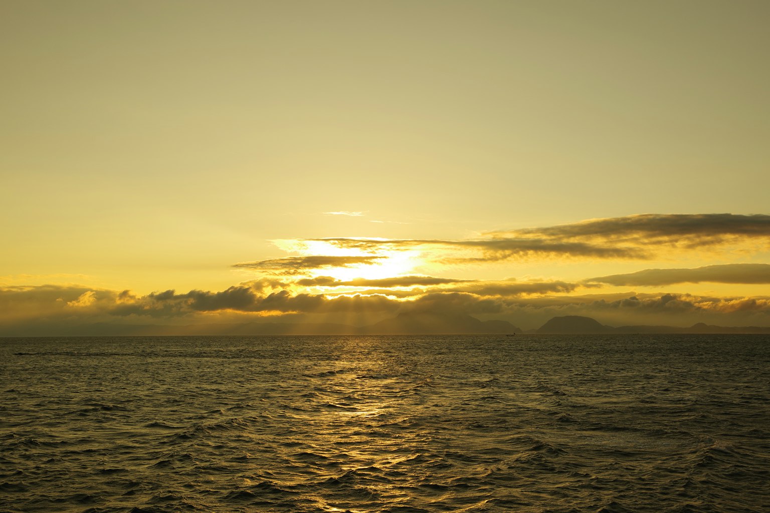 Atardecer sobre el océano con reflejos en el agua