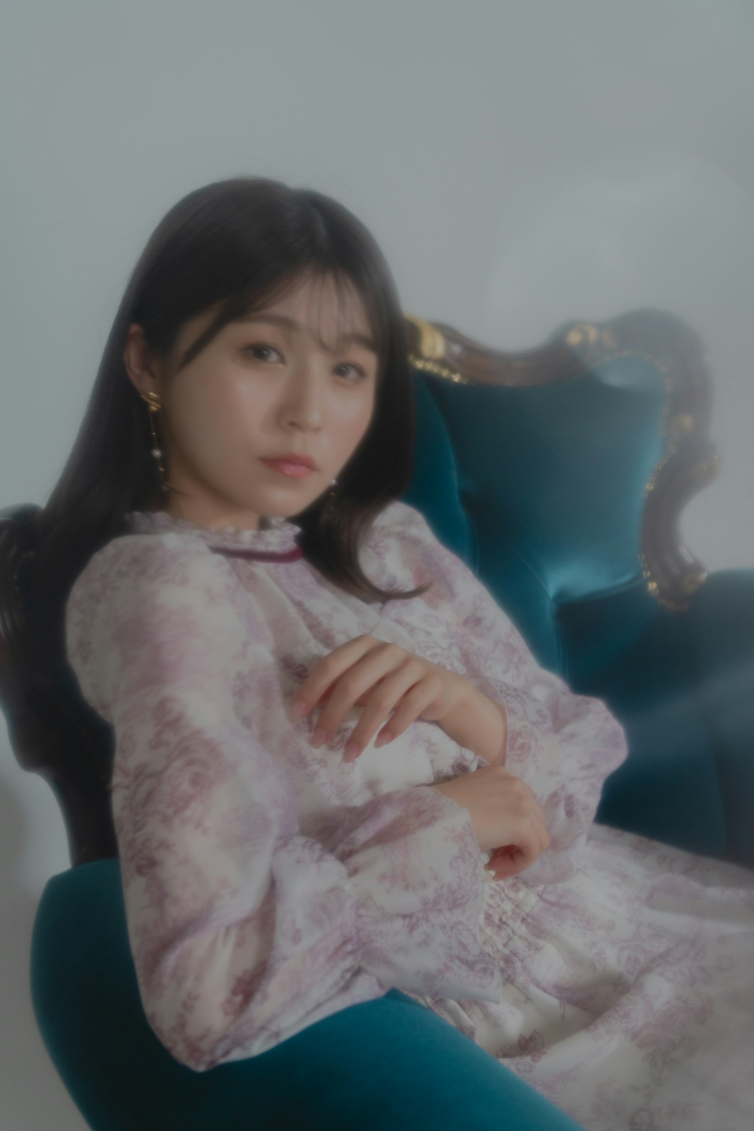 一位女性坐在蓝色沙发上，照片光线柔和