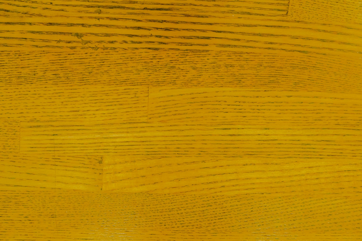 Oberfläche aus gelbem Holz mit feinen Maserungsmustern und glatter Textur