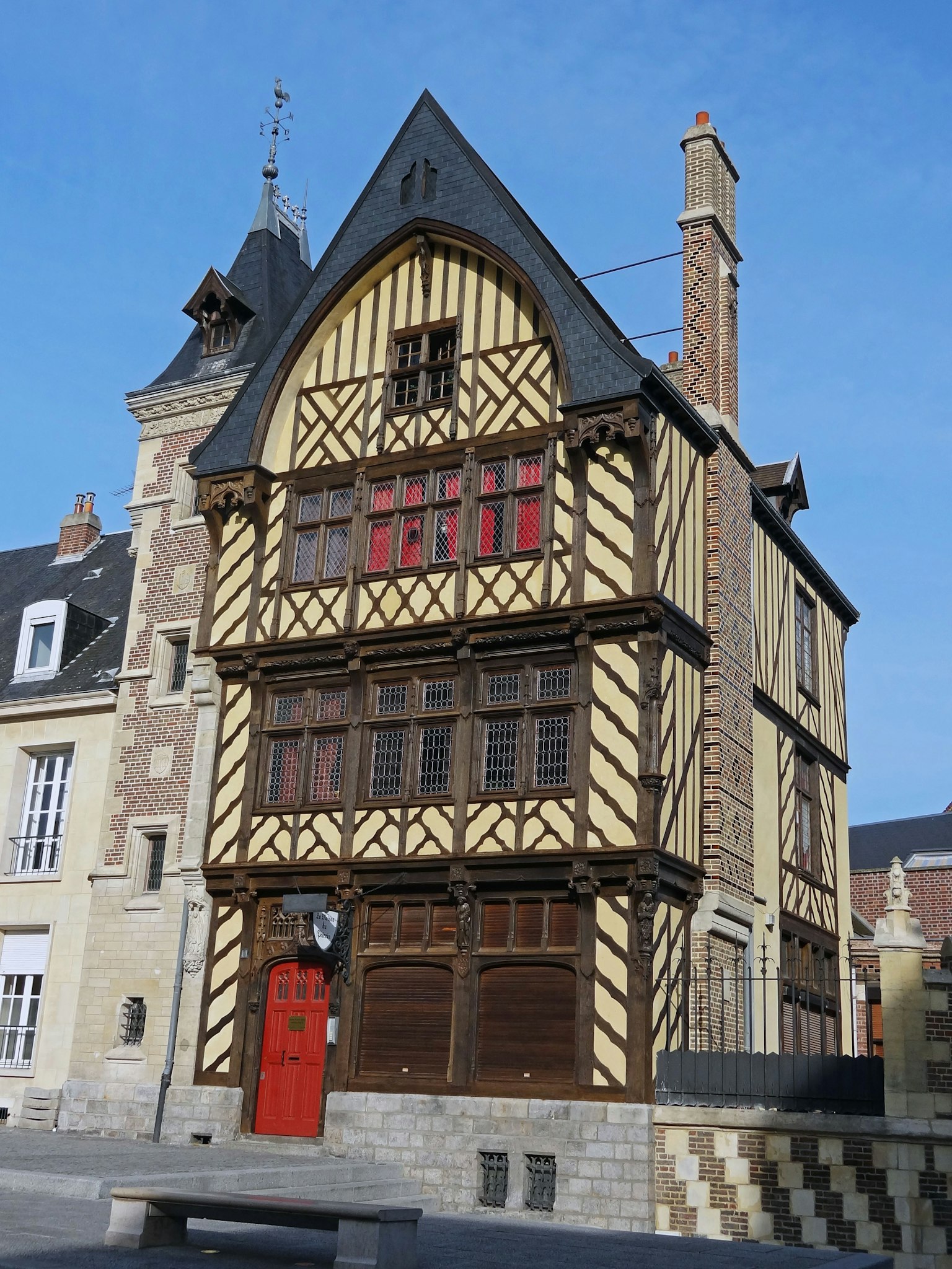 Historic French building with a red door and timber-framed facade