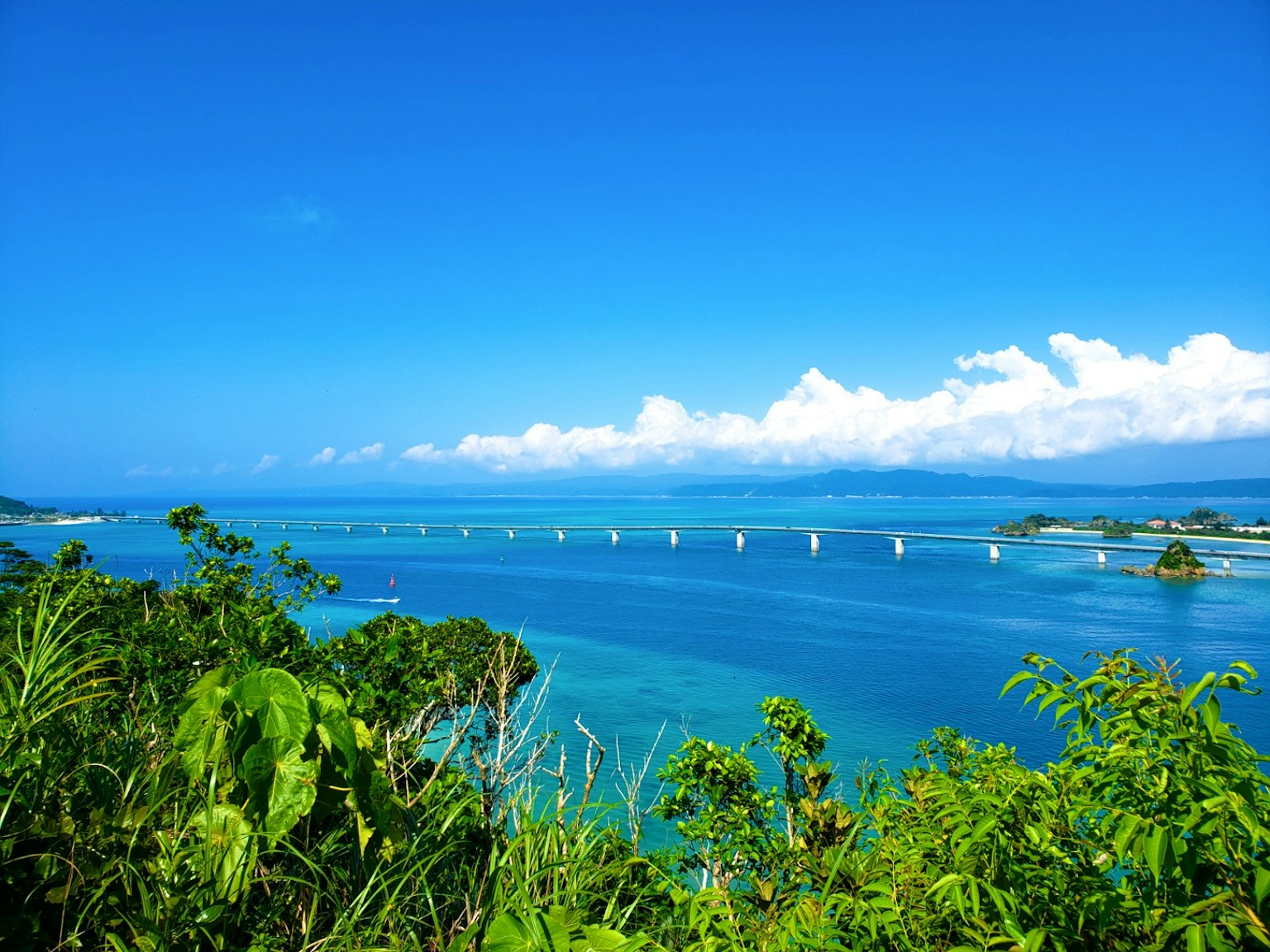 ทิวทัศน์ที่สวยงามมีทะเลและท้องฟ้าสีฟ้าและสะพานข้ามน้ำ