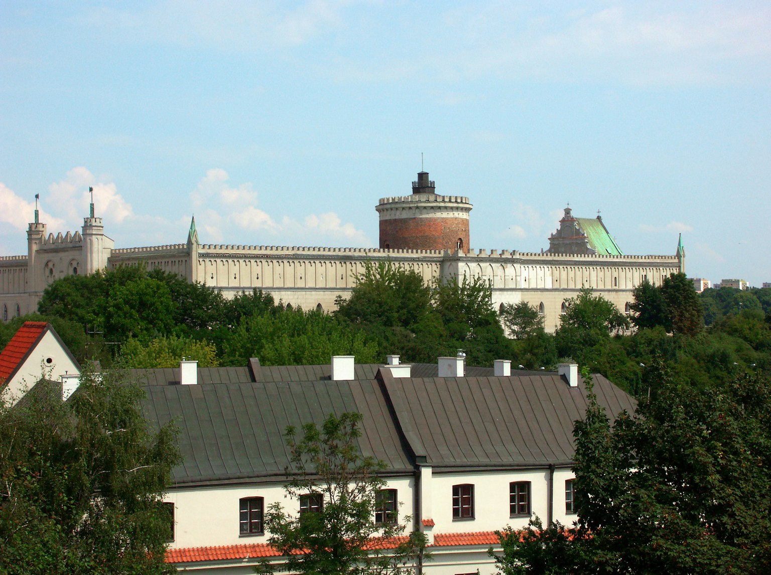 Landschaft mit einer Festung und Türmen, umgeben von Grünflächen